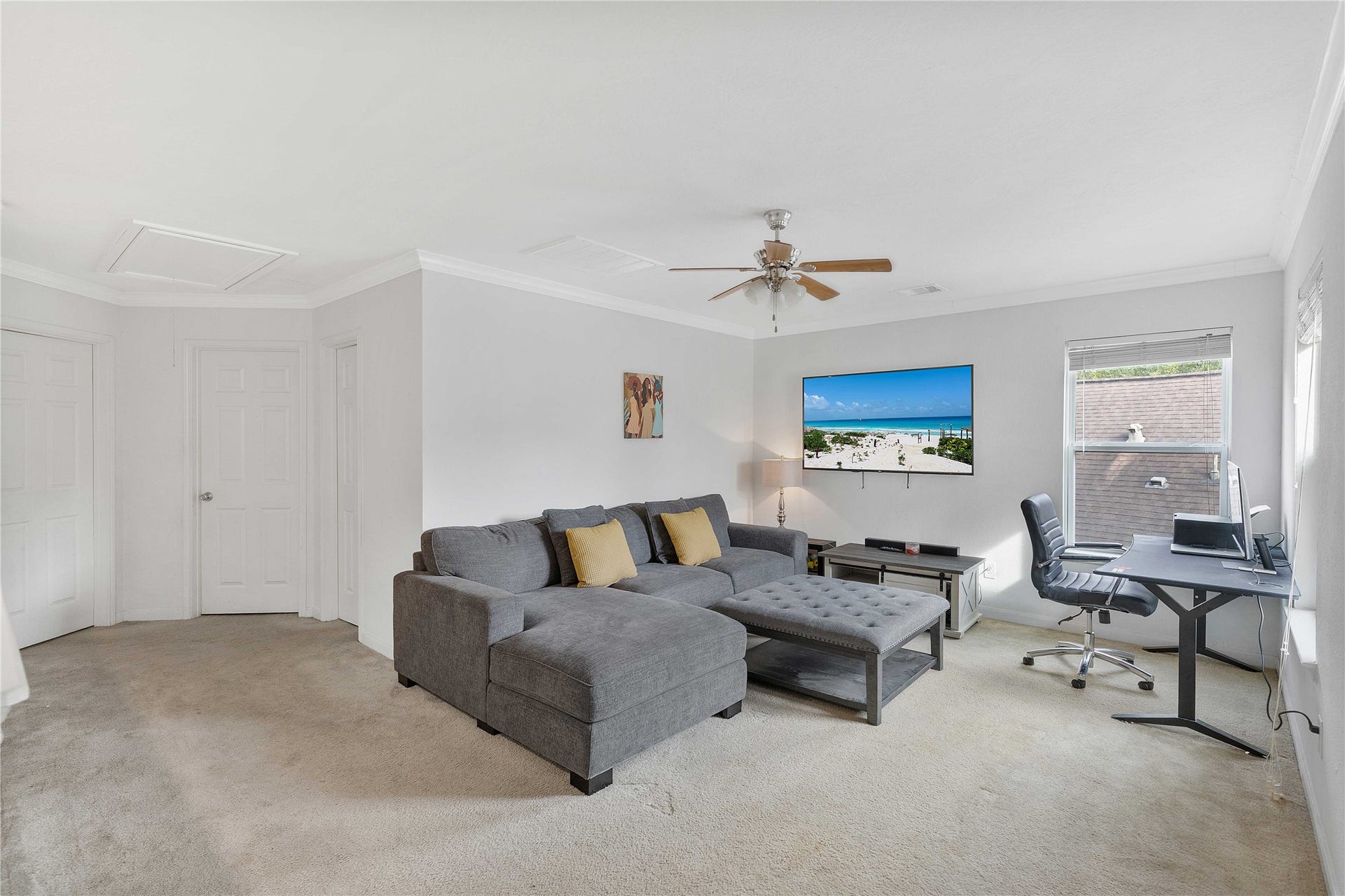 2910 Ribbon Creek Way, Spring, TX 77389 Spacious living area with a comfortable sectional sofa and entertainment setup, featuring a work-from-home desk by a bright window.