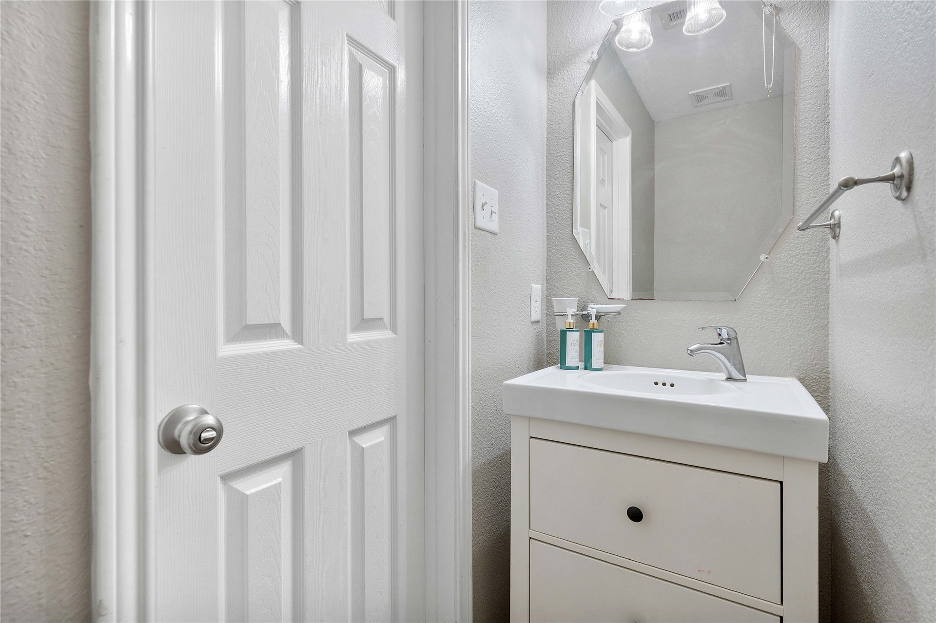 2910 Ribbon Creek Way, Spring, TX 77389 Charming half-bathroom featuring a sleek vanity with modern fixtures, complemented by a stylish mirror and neutral tones.