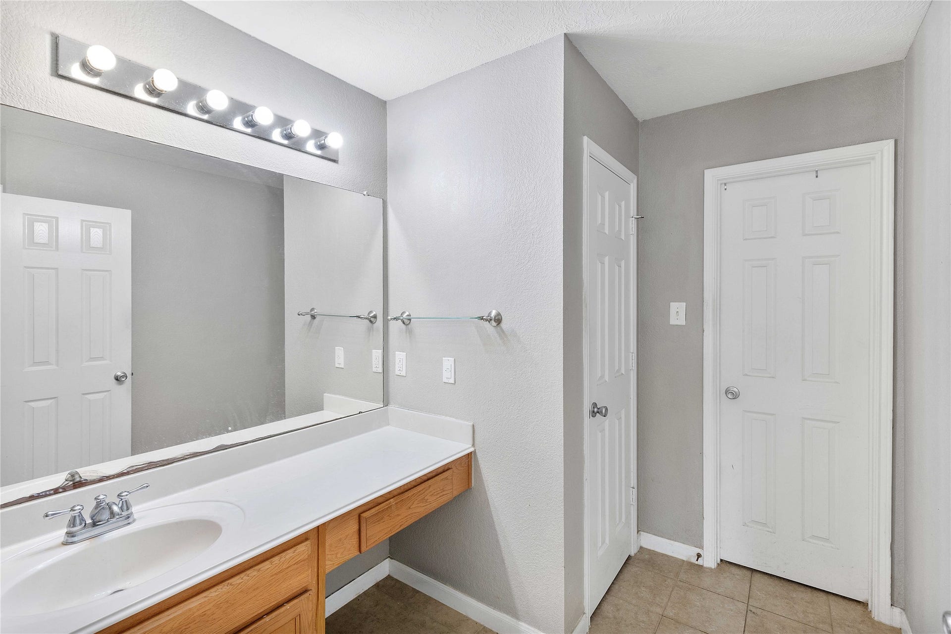 2910 Ribbon Creek Way, Spring, TX 77389 Modern bathroom featuring a spacious vanity with ample counter space, sleek lighting, and neutral tile flooring.