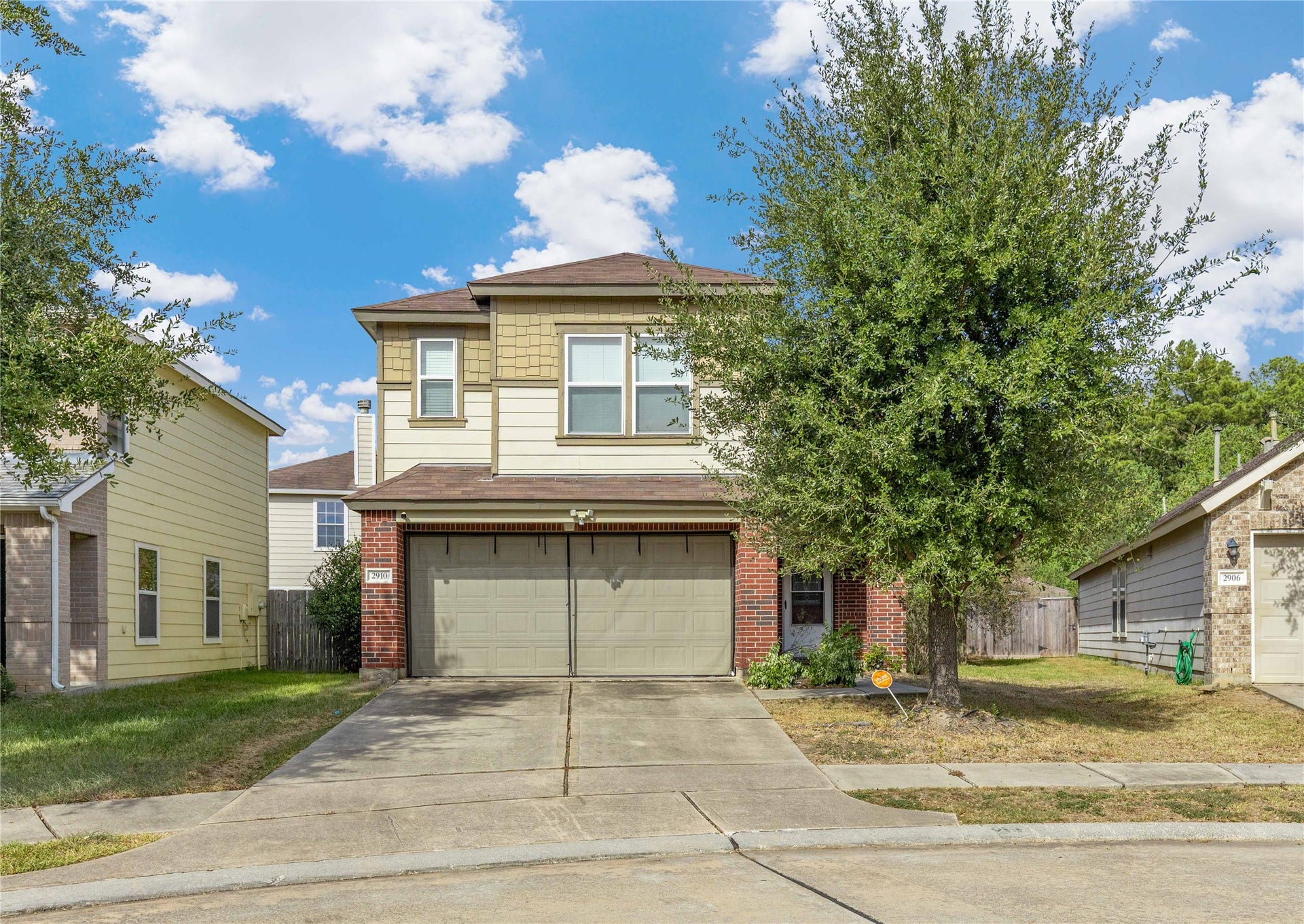 2910 Ribbon Creek Way, Spring, TX 77389 Charming two-story home with a brick facade and attached two-car garage, nestled in a quiet suburban neighborhood.