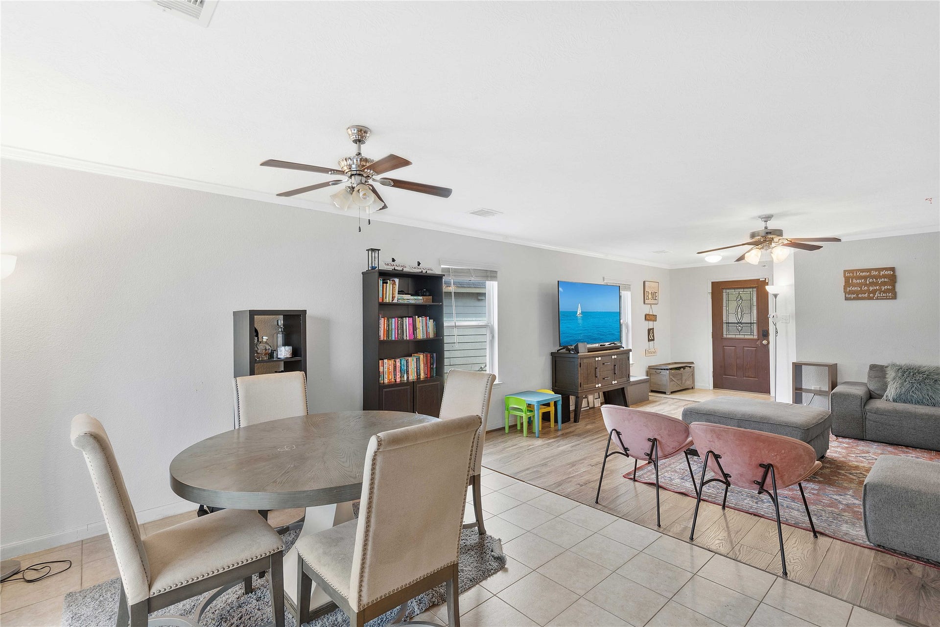 2910 Ribbon Creek Way, Spring, TX 77389 Spacious open-concept living area featuring a cozy dining space, stylish ceiling fans, and a comfortable seating arrangement ideal for relaxation and entertainment.