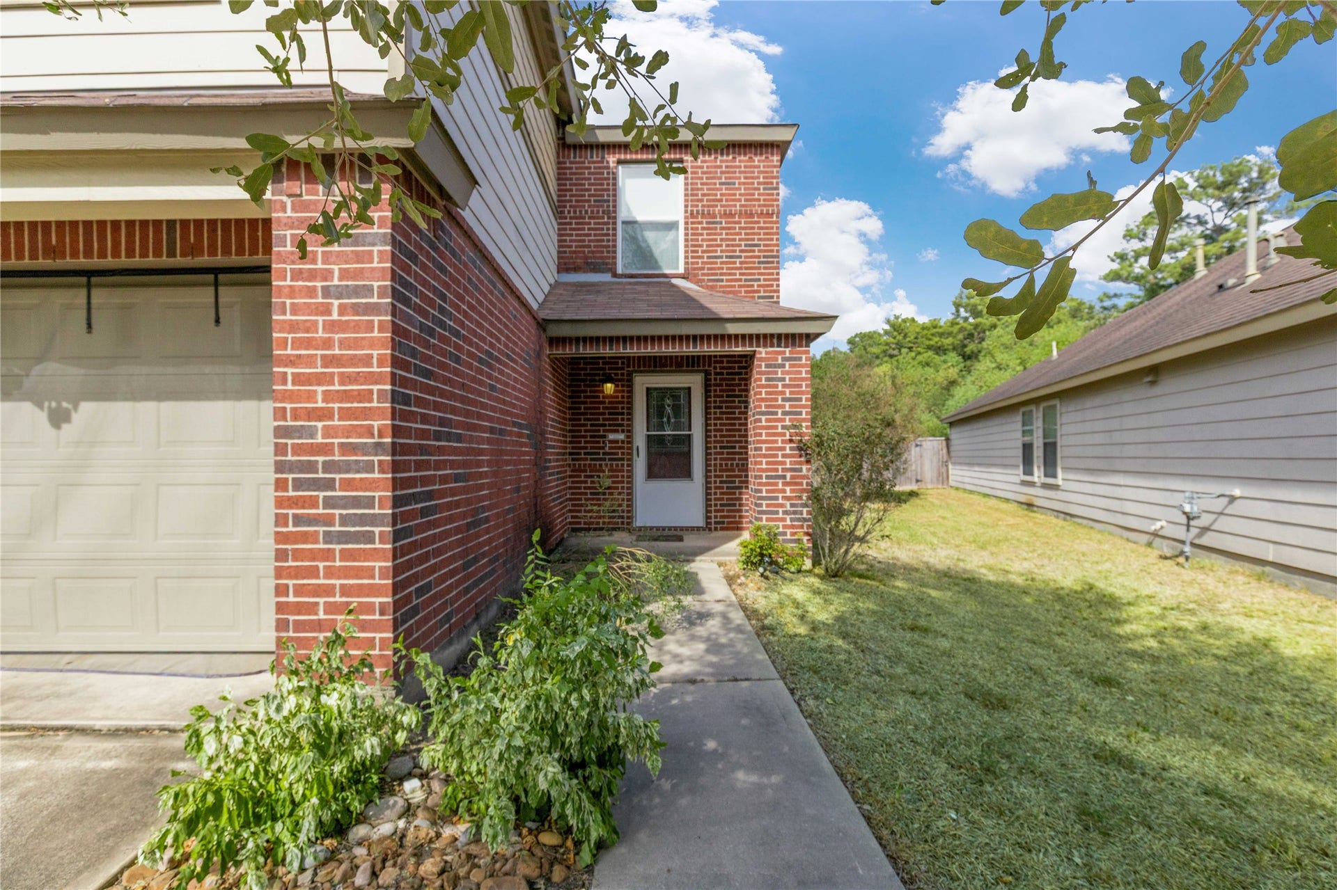 2910 Ribbon Creek Way, Spring, TX 77389 Charming brick exterior with a welcoming walkway leads to the front entrance, complemented by a well-maintained lawn and lush greenery.