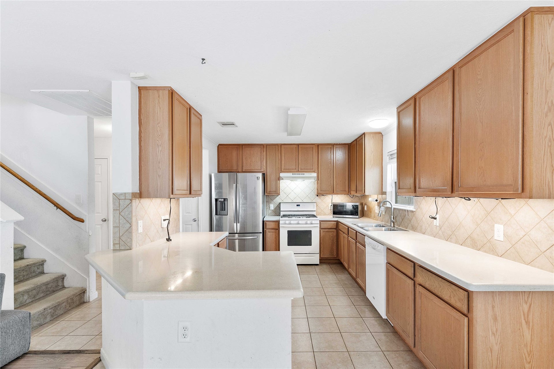 2910 Ribbon Creek Way, Spring, TX 77389 Spacious kitchen with ample wooden cabinetry, sleek countertops, and modern stainless steel appliances, offering a perfect blend of style and functionality.