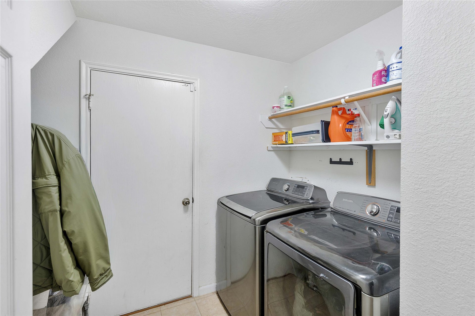 2910 Ribbon Creek Way, Spring, TX 77389 Modern laundry room with sleek appliances, ample shelving for storage, and convenient hanging space.