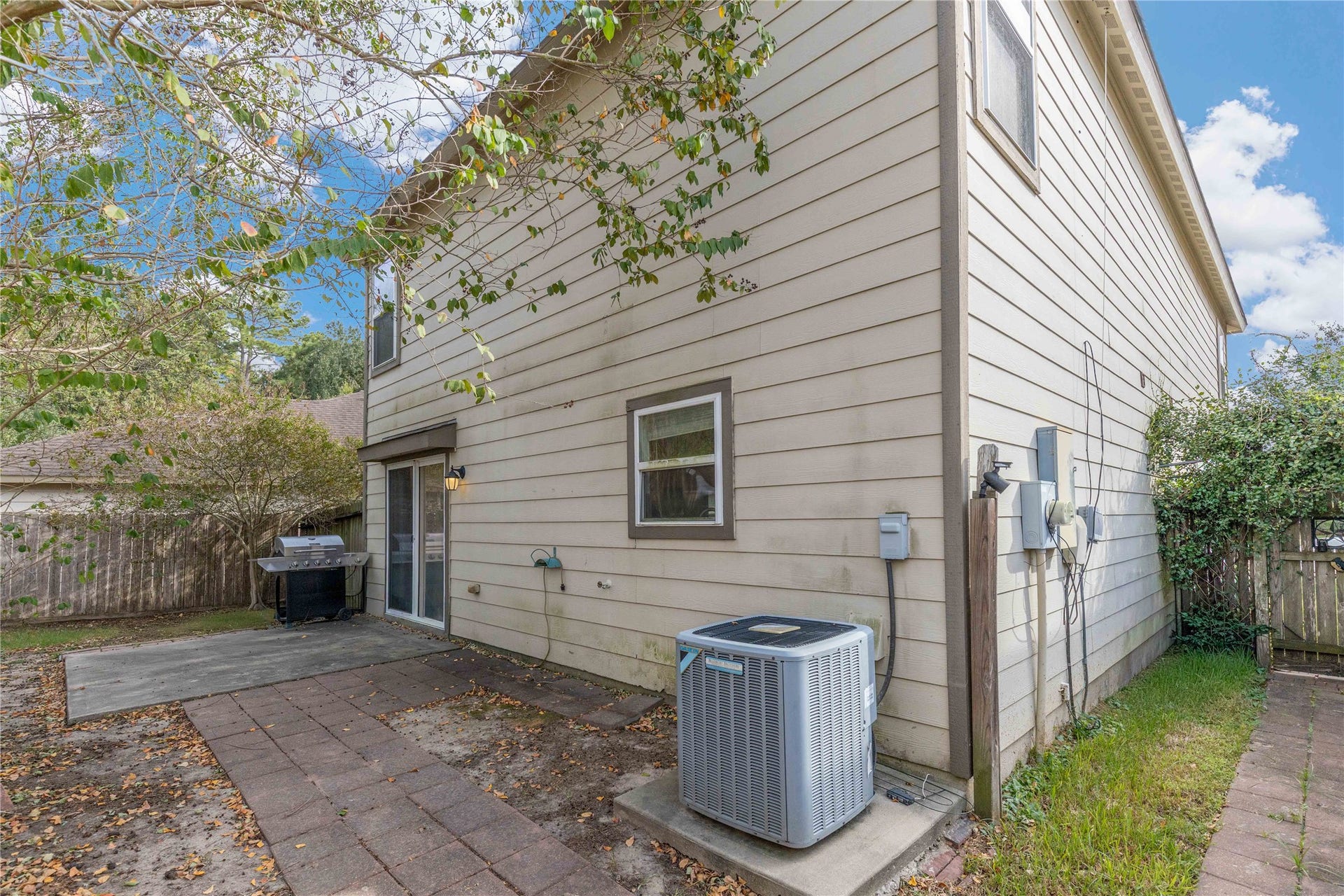 2910 Ribbon Creek Way, Spring, TX 77389 Charming backyard with a spacious patio perfect for outdoor grilling and relaxation, surrounded by mature trees for added privacy.