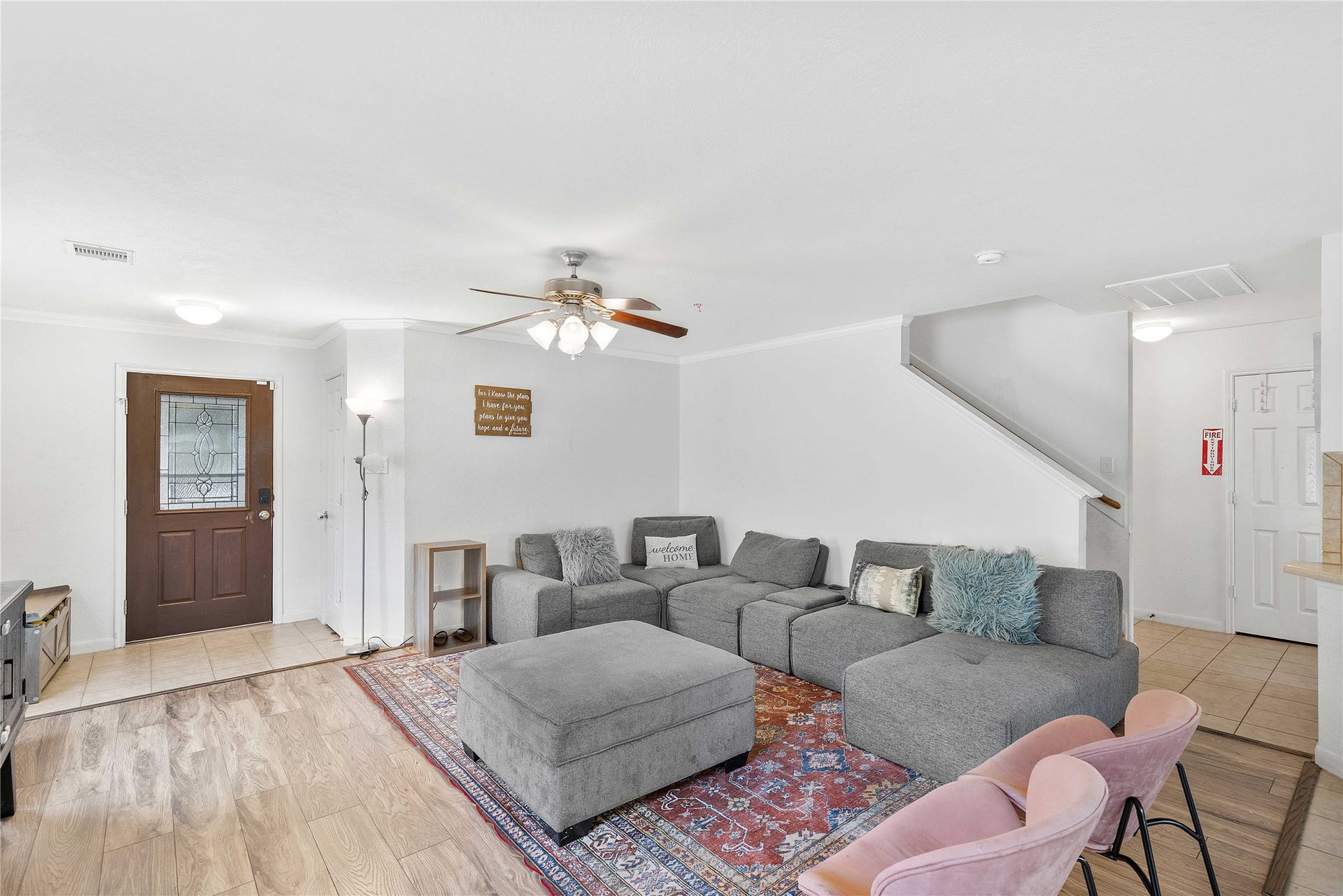 2910 Ribbon Creek Way, Spring, TX 77389 Spacious living area with a large sectional sofa, ceiling fan, and a mix of wood and tile flooring, creating a cozy and inviting atmosphere.