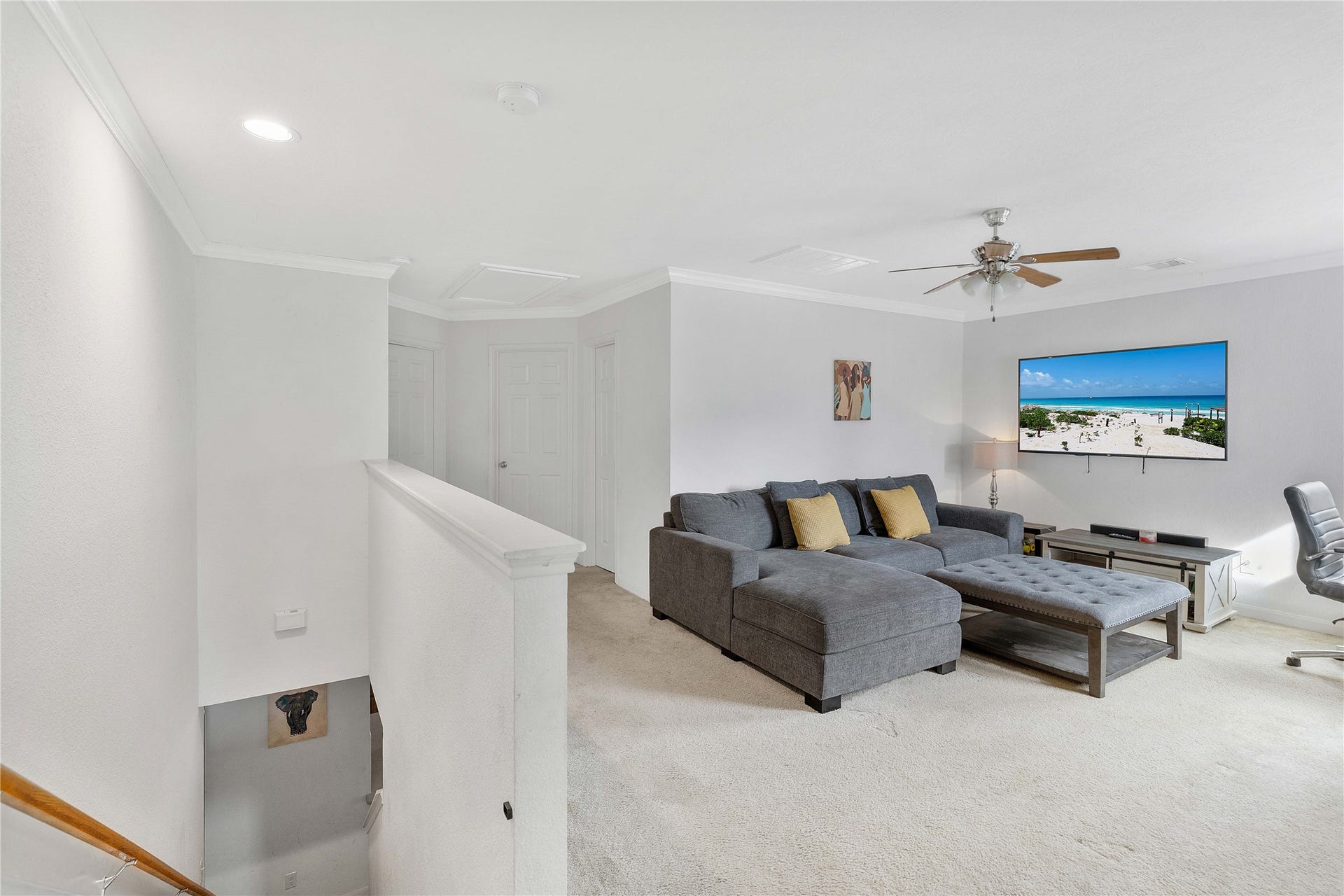 2910 Ribbon Creek Way, Spring, TX 77389 Spacious and bright living area featuring a cozy sectional sofa, wall-mounted TV, and ceiling fan, perfect for relaxation.