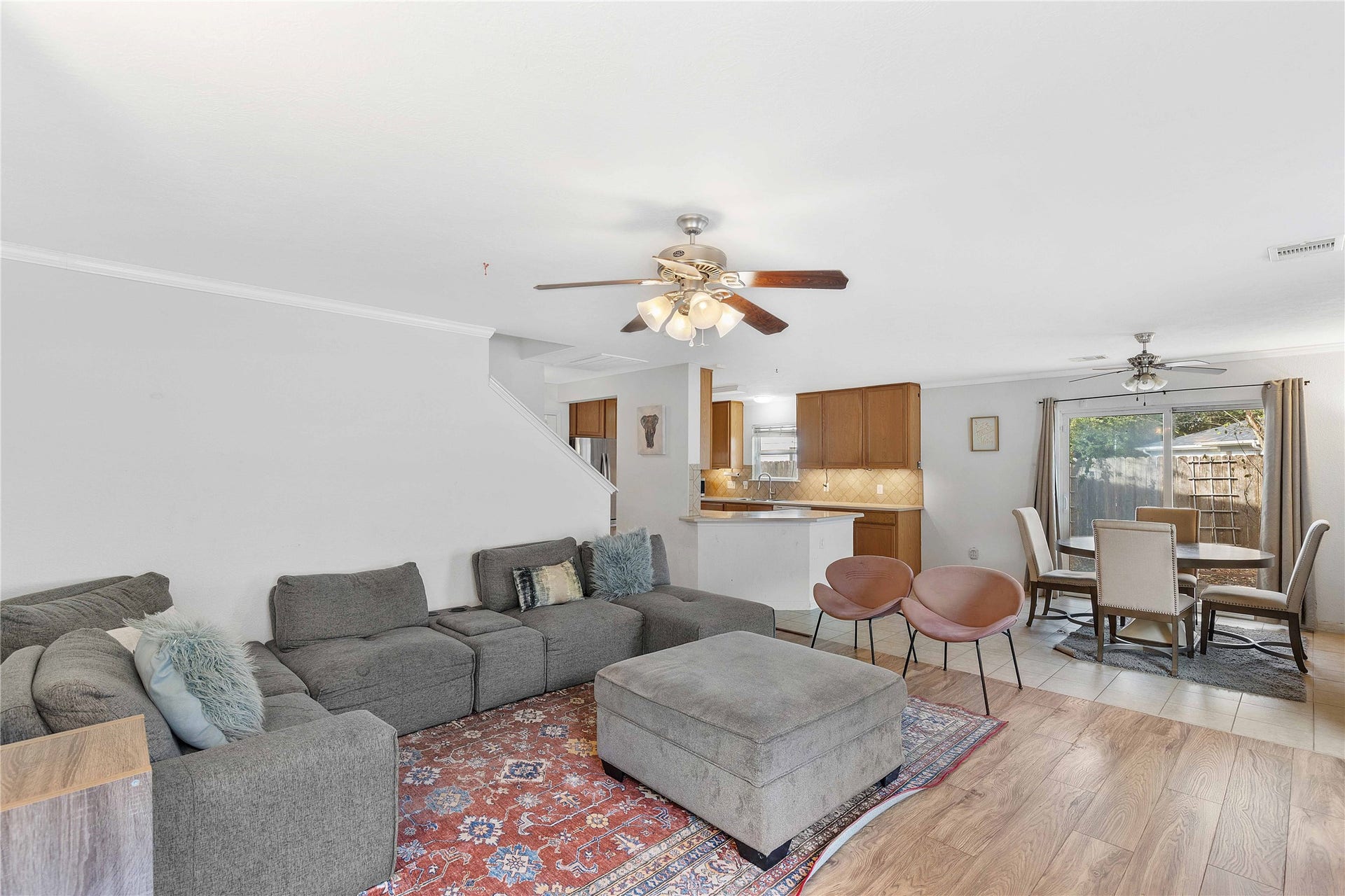 2910 Ribbon Creek Way, Spring, TX 77389 Spacious open-concept living area featuring a cozy sectional sofa, stylish dining space, and a modern kitchen with ample cabinetry, perfect for entertaining and family gatherings.