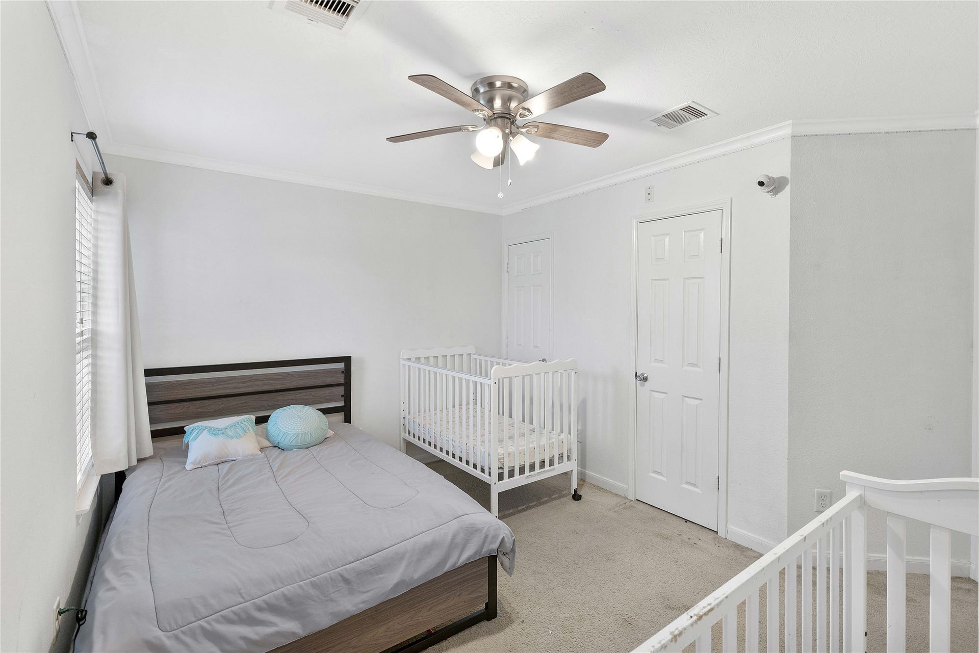 2910 Ribbon Creek Way, Spring, TX 77389 Bright and cozy bedroom featuring a comfortable bed, a crib, soft carpeting, and a ceiling fan for added comfort.
