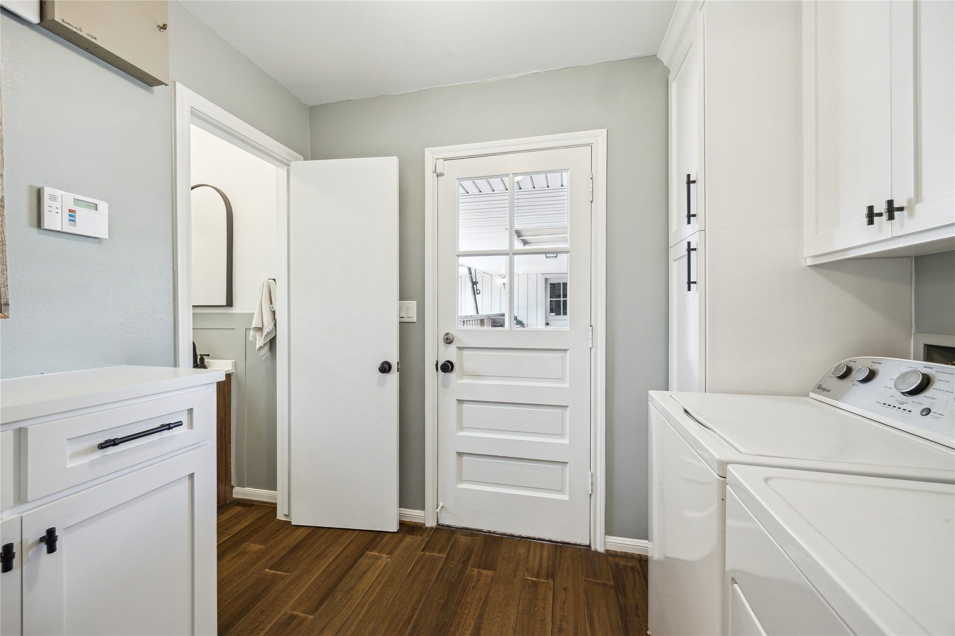 10714 Piping Rock Lane, Houston, TX 77042 Cabinetry above the washer and dryer adds storage, while an exterior door provides convenient outdoor access.