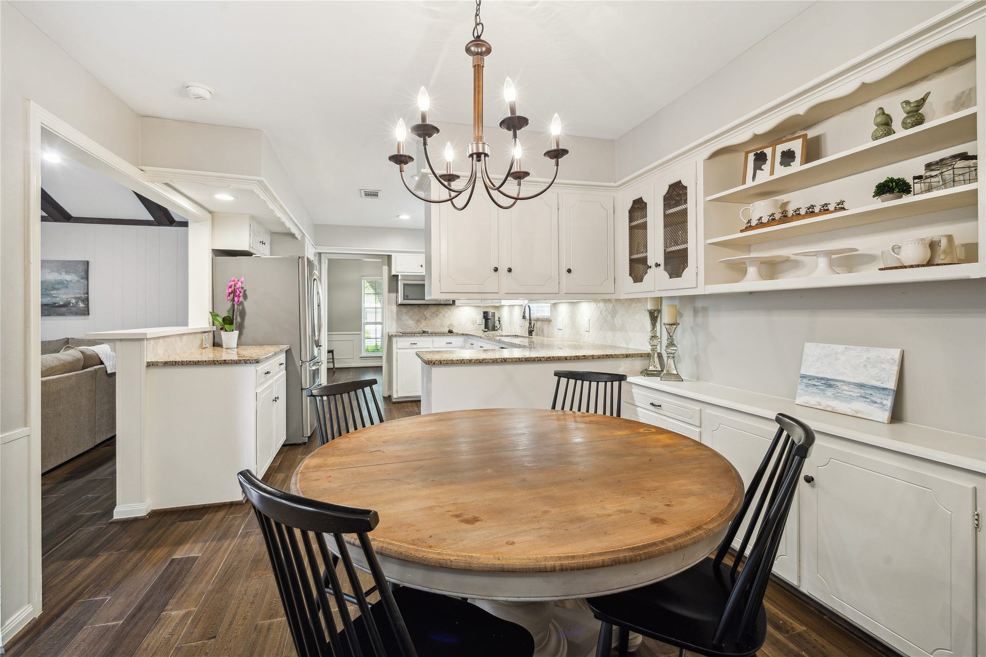 10714 Piping Rock Lane, Houston, TX 77042 A chandelier defines the dining space, while built-in storage and a nearby breakfast bar connect it naturally to the kitchen.