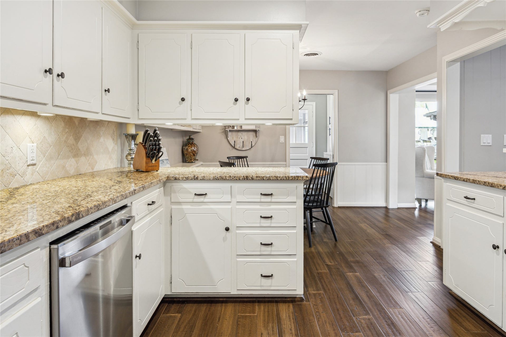 10714 Piping Rock Lane, Houston, TX 77042 Ample cabinetry and counter space provide room for meal preparation, while wood flooring connects the kitchen to nearby living spaces.