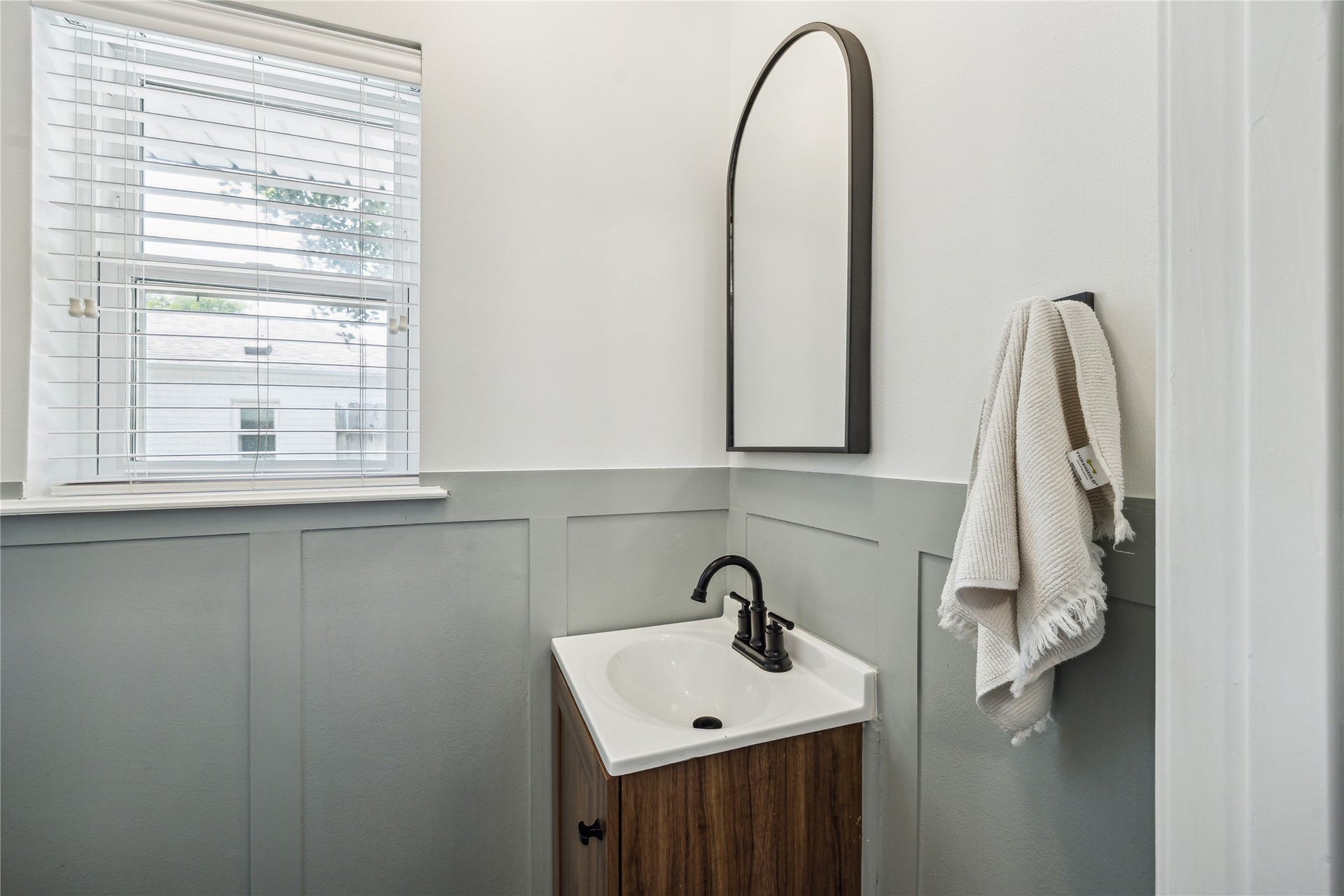 10714 Piping Rock Lane, Houston, TX 77042 Two-tone walls, decorative paneling and a wood-tone vanity give this powder room a distinctive look