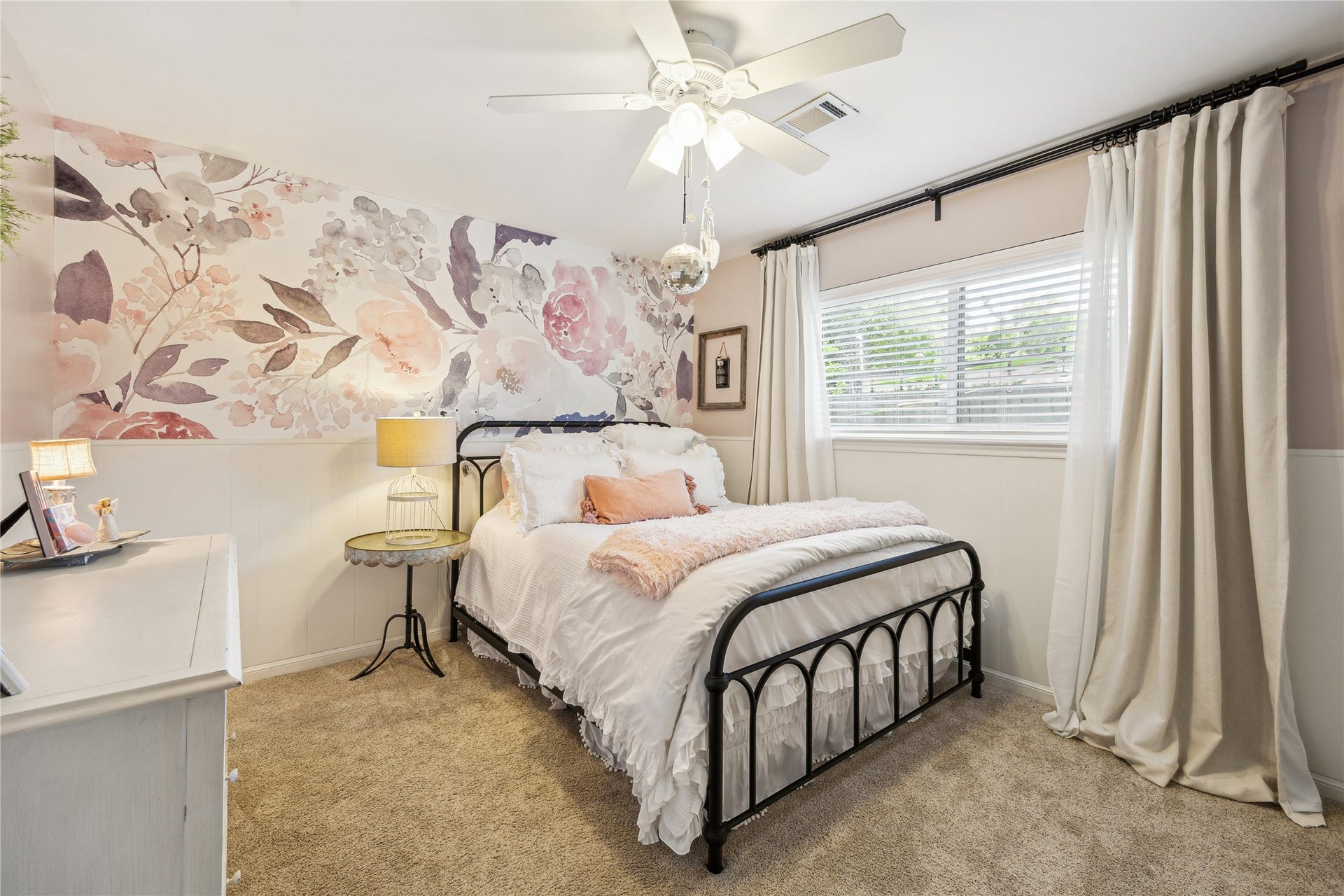 10714 Piping Rock Lane, Houston, TX 77042 A floral accent wall adds personality to this bedroom, complemented by a large window and ceiling fan.