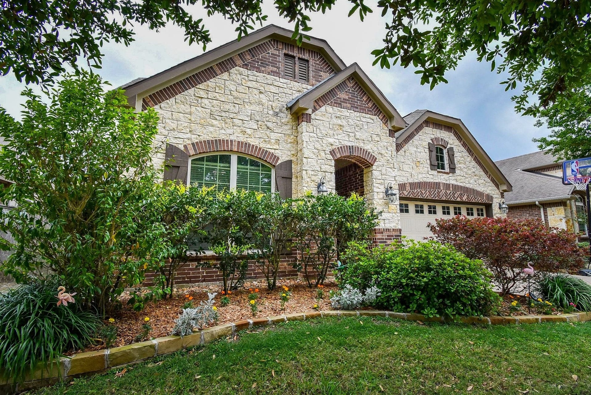 Welcome home! Classic stone and brick exterior and well-maintained landscaping welcome you in.