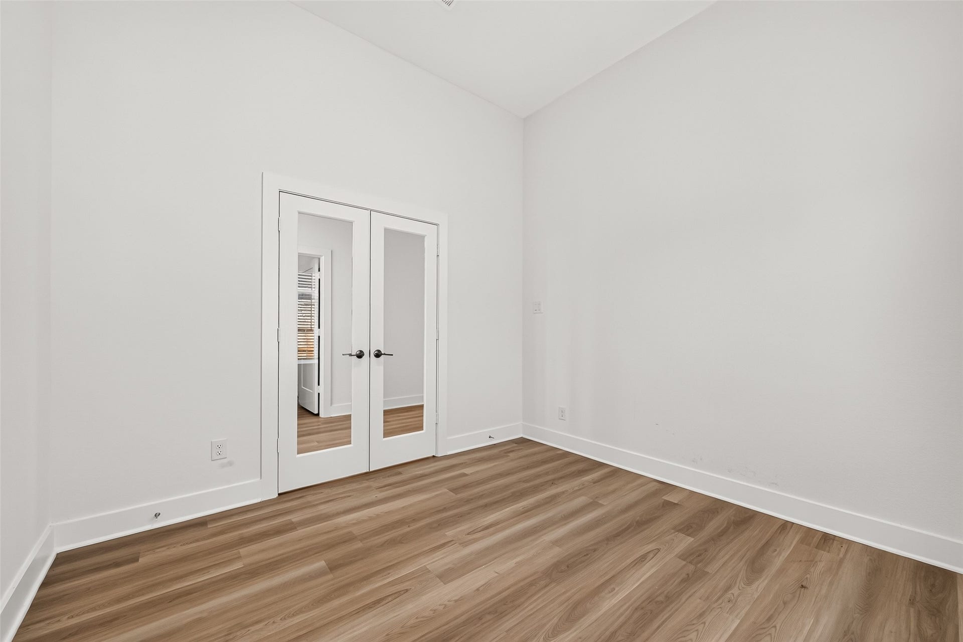 2002 Flatland Drive, Rosenberg, TX 77471 Flex room with French glass doors, vaulted ceiling, and wood-look flooring. Works well as a home office or study.