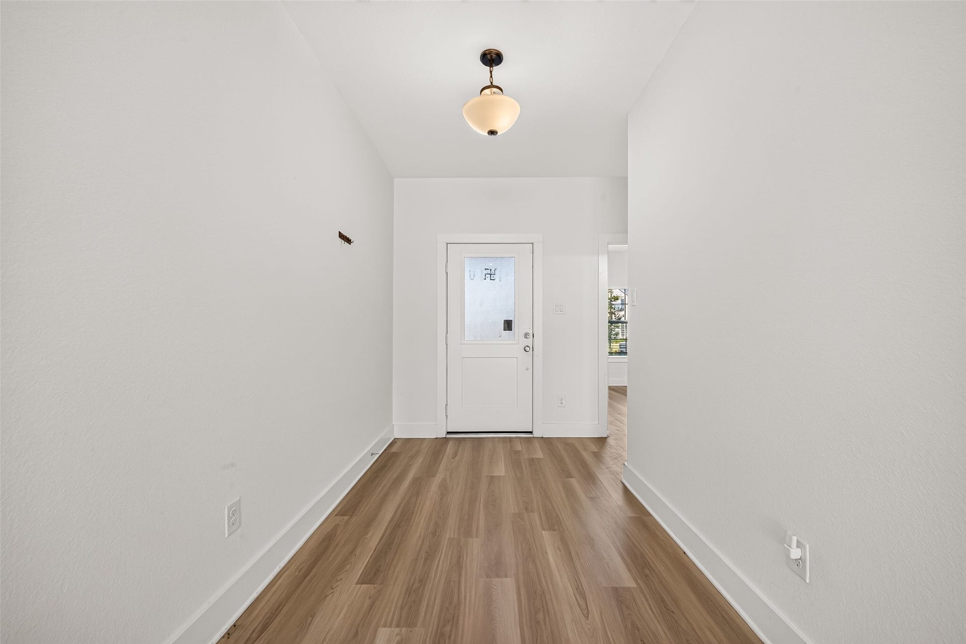 2002 Flatland Drive, Rosenberg, TX 77471 Entry hall with wood-look flooring, pendant light fixture, and neutral paint.