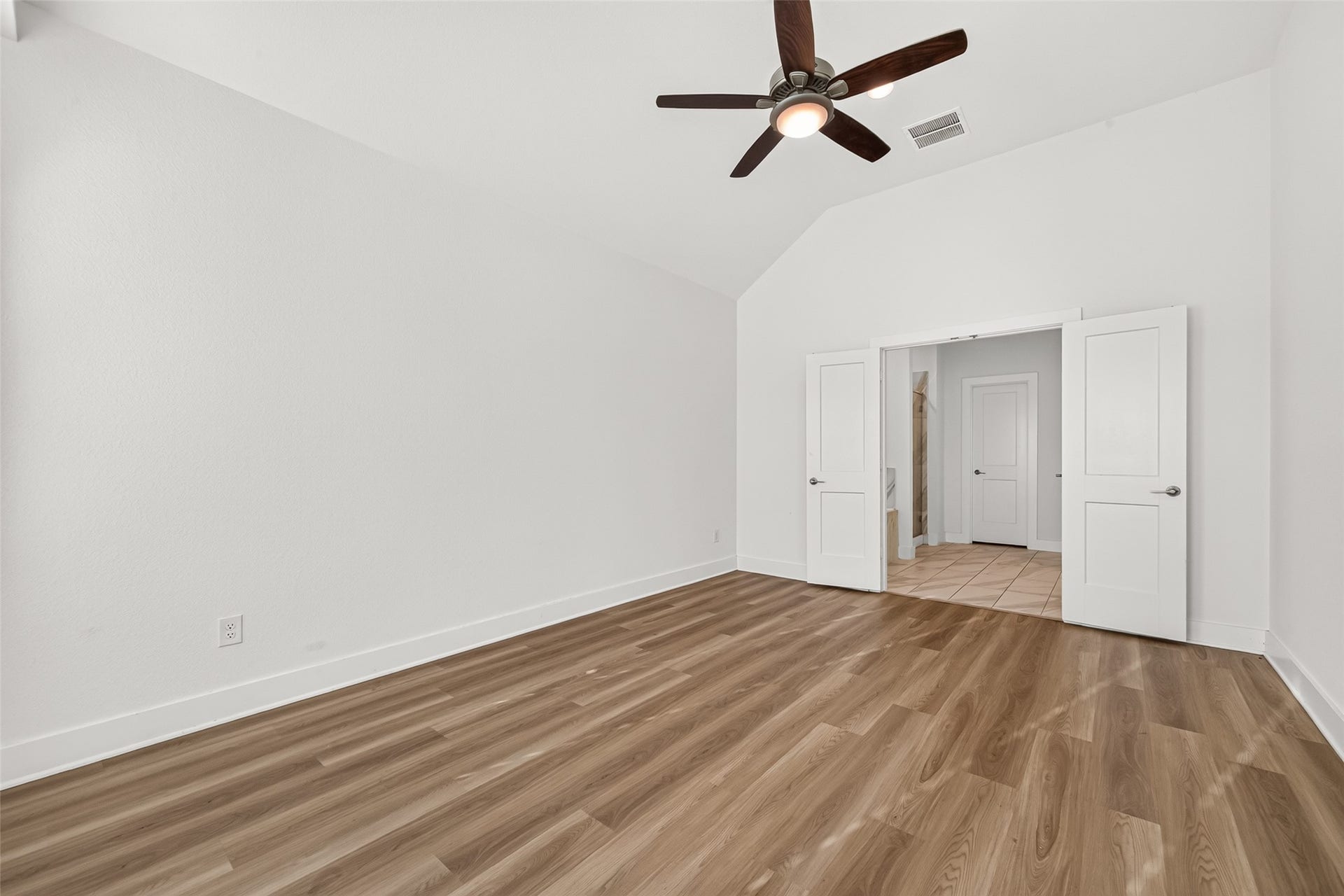 2002 Flatland Drive, Rosenberg, TX 77471 Primary bedroom with vaulted ceiling and double doors to the hallway.
