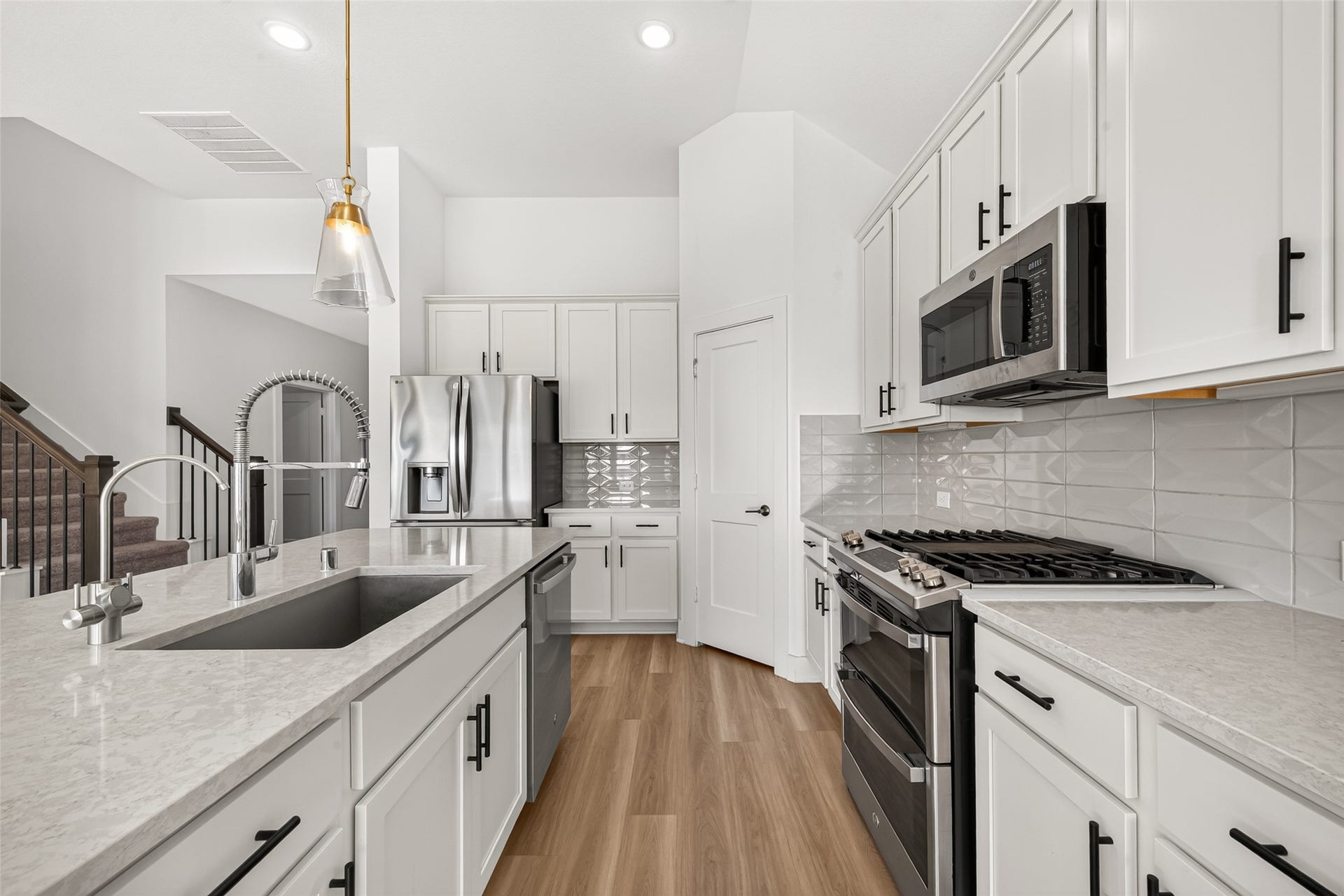 2002 Flatland Drive, Rosenberg, TX 77471 Kitchen with gas range, stainless steel appliances, ample counter space, and white cabinets with black hardware.