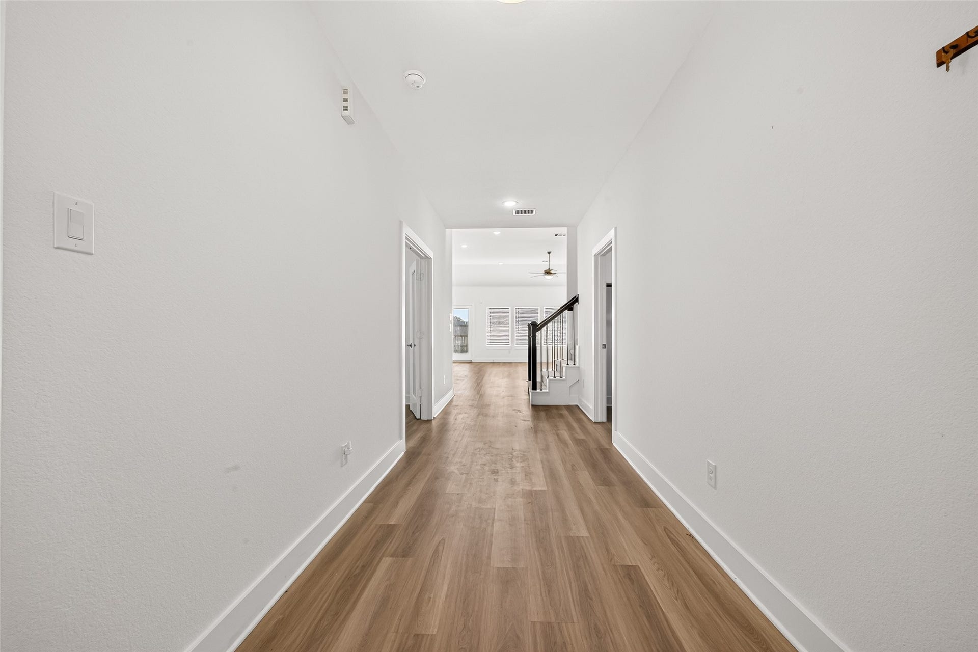 2002 Flatland Drive, Rosenberg, TX 77471 Hallway with wood-look flooring leading from the entry to the open living area and staircase.