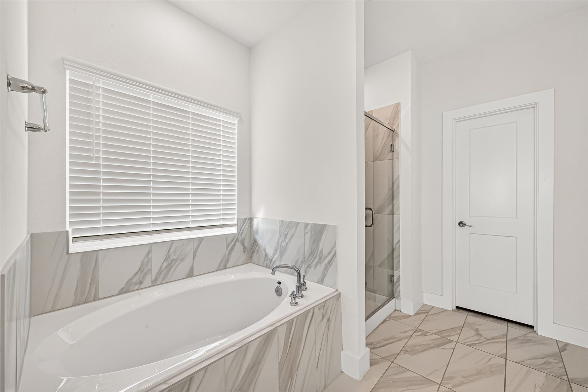 2002 Flatland Drive, Rosenberg, TX 77471 Primary bathroom with soaking tub, marble-look tile surround, and separate shower.