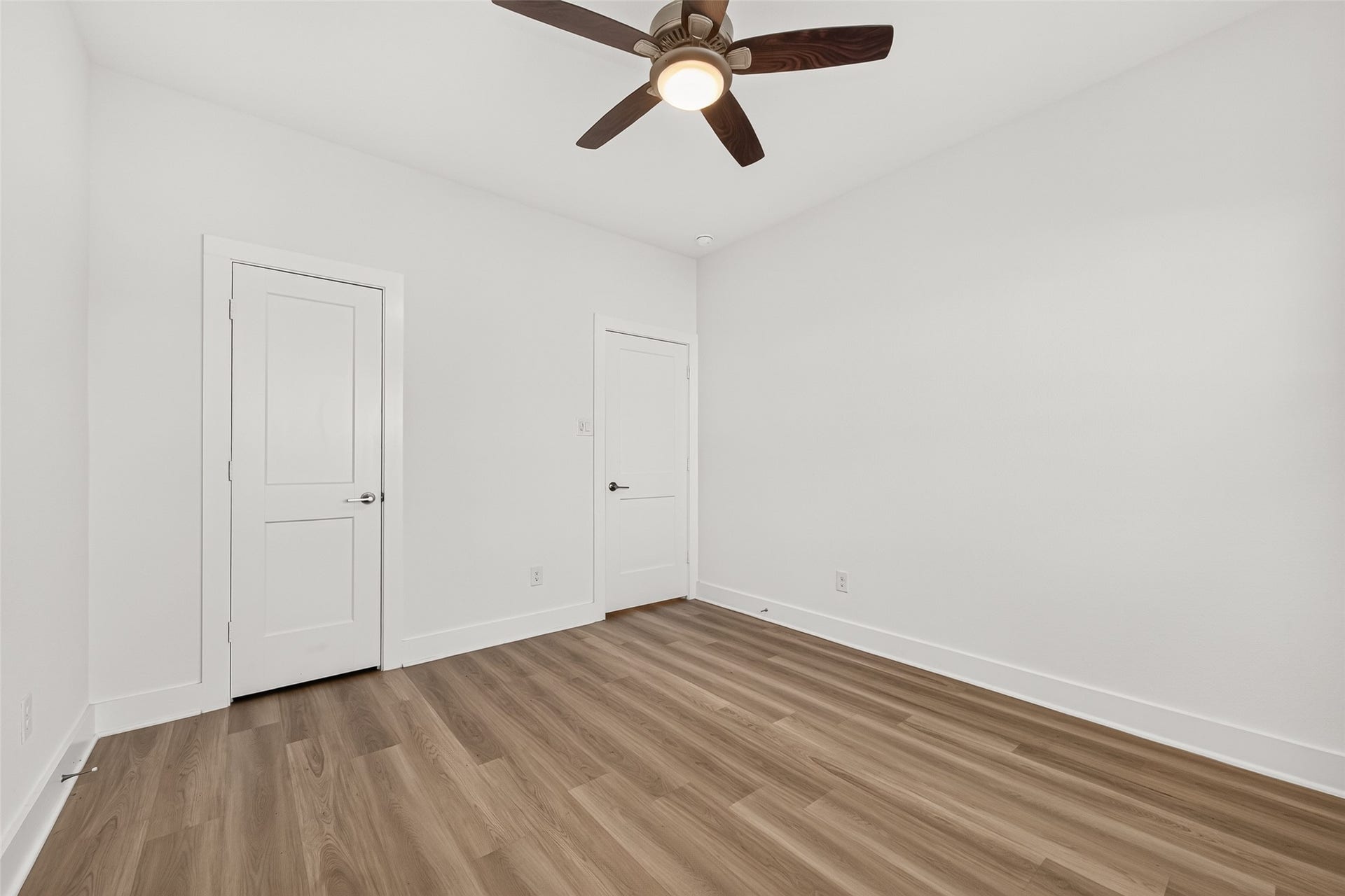 2002 Flatland Drive, Rosenberg, TX 77471 Bedroom view showing closet doors, ceiling fan, and wood-look flooring.