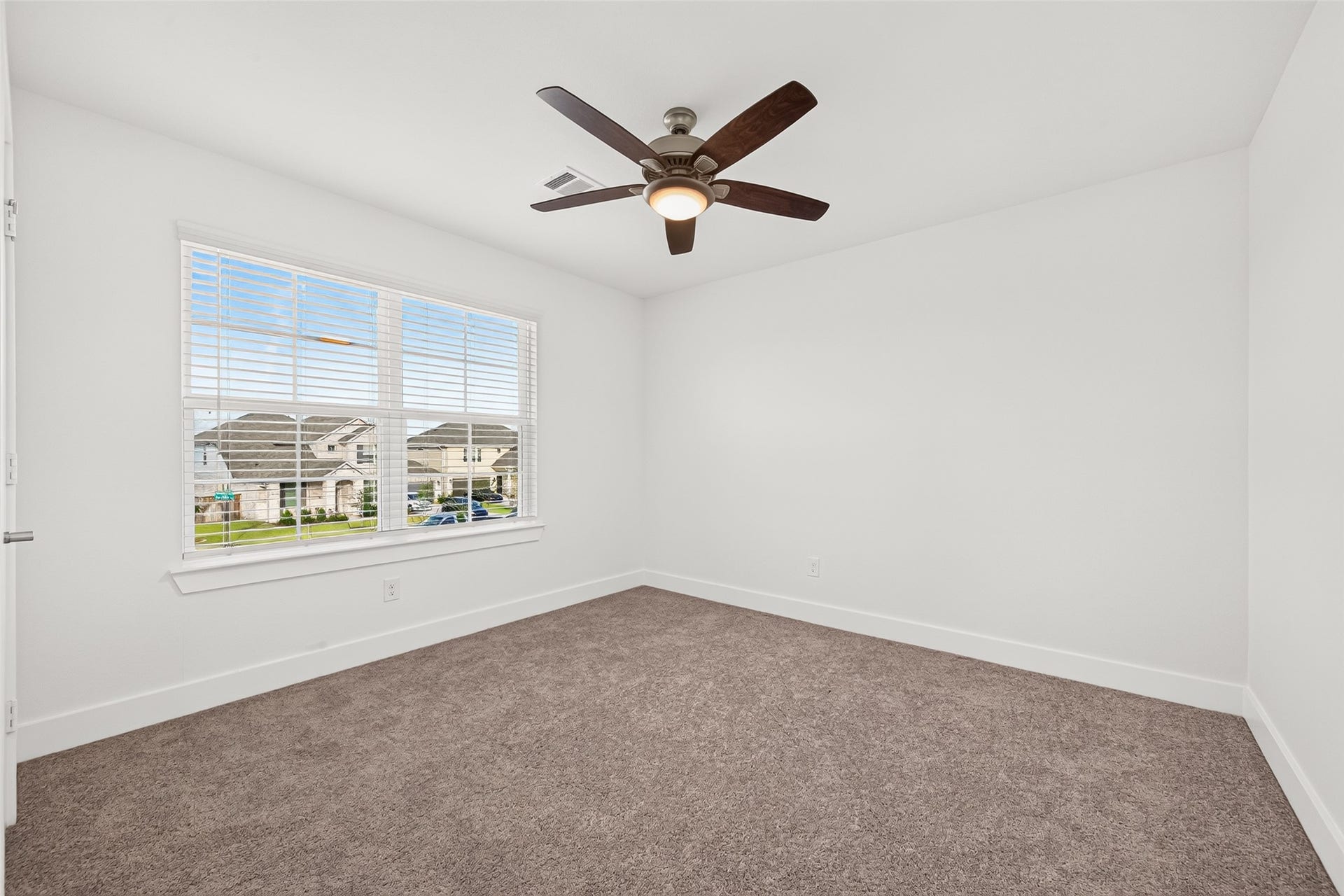 2002 Flatland Drive, Rosenberg, TX 77471 Upstairs bedroom with carpet, ceiling fan, and window with blinds.