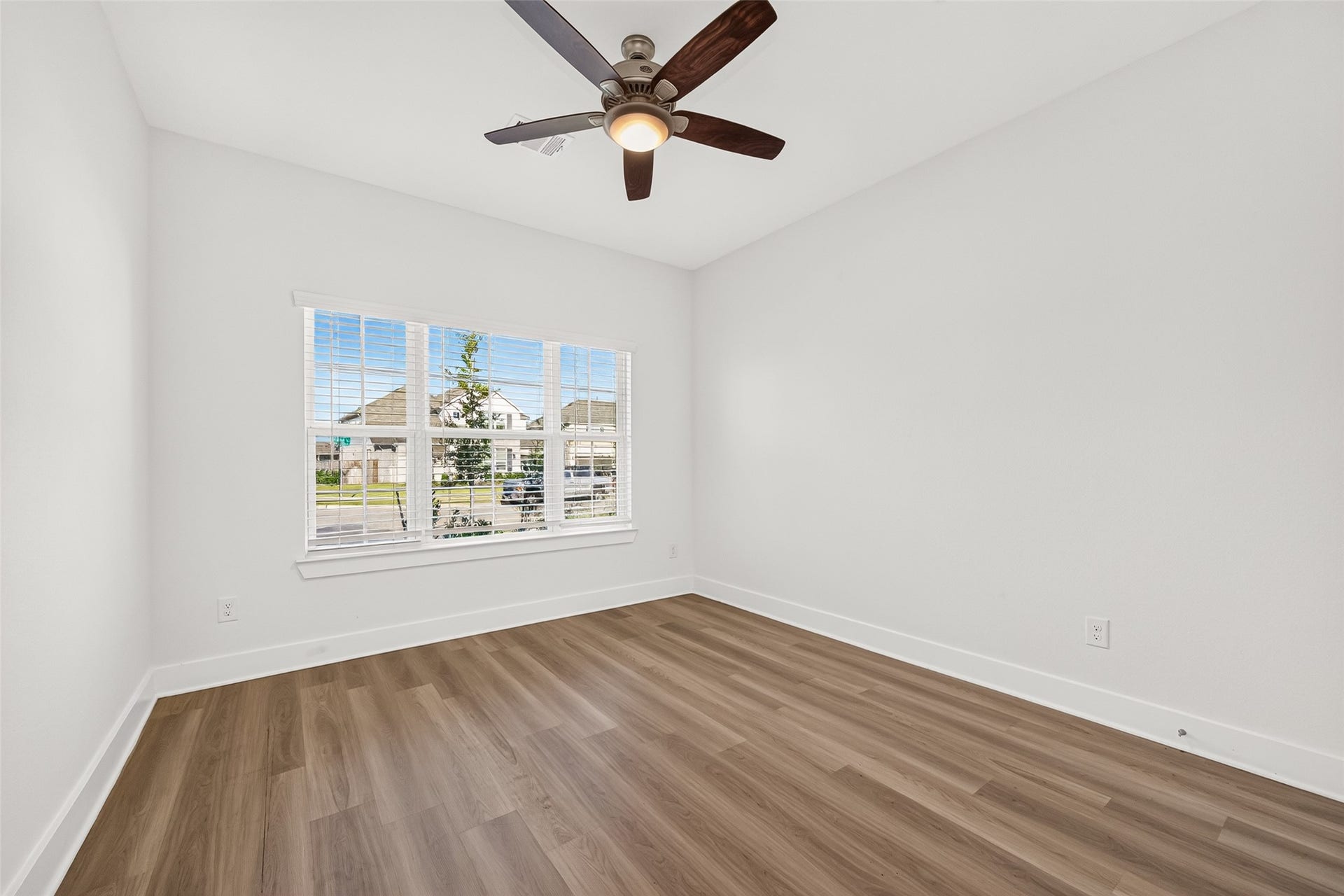 2002 Flatland Drive, Rosenberg, TX 77471 Bedroom with ceiling fan, wood-look flooring, and a front-facing window.