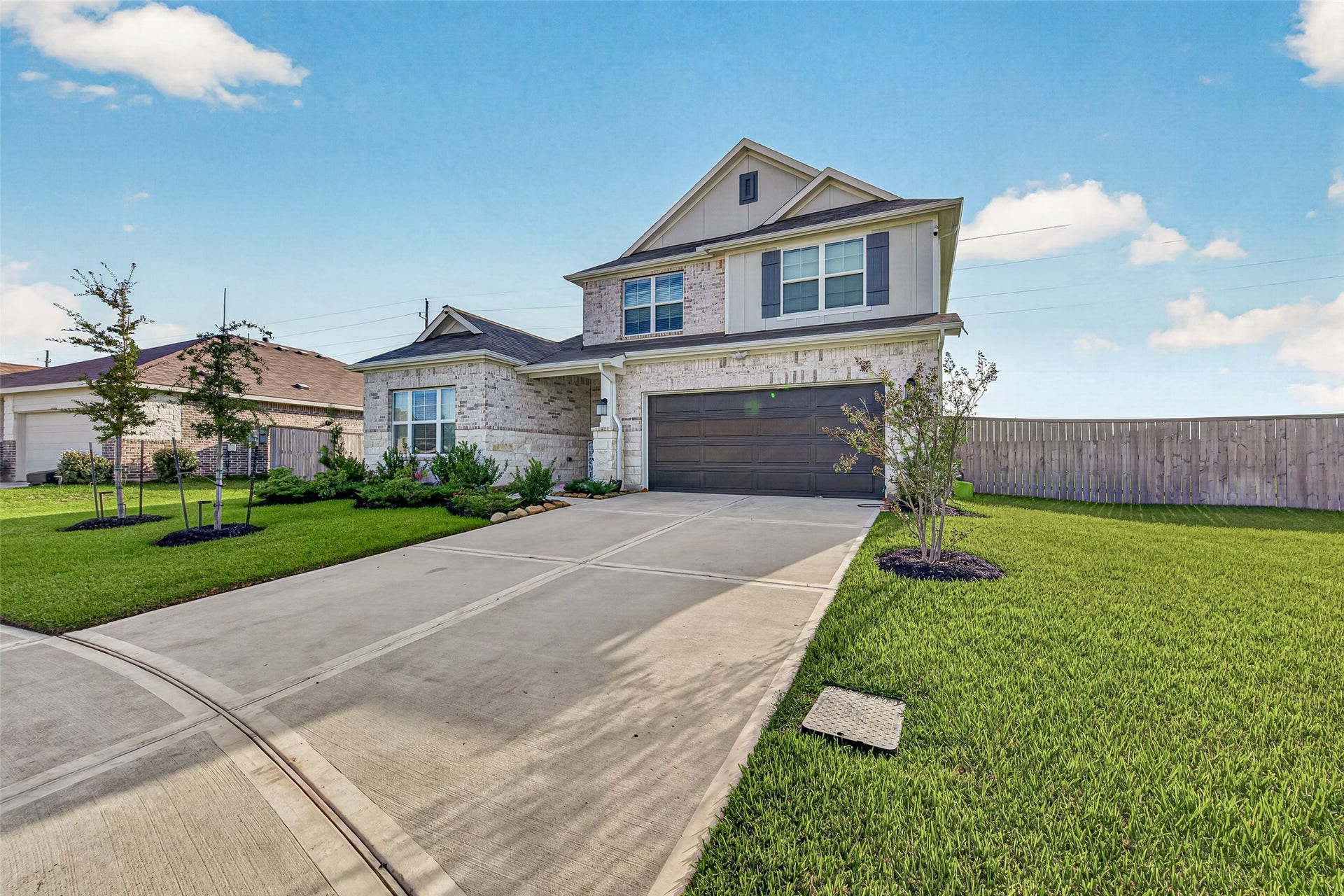 2002 Flatland Drive, Rosenberg, TX 77471 Two-story brick and stone home with a two-car garage, long driveway, and landscaped front lawn.