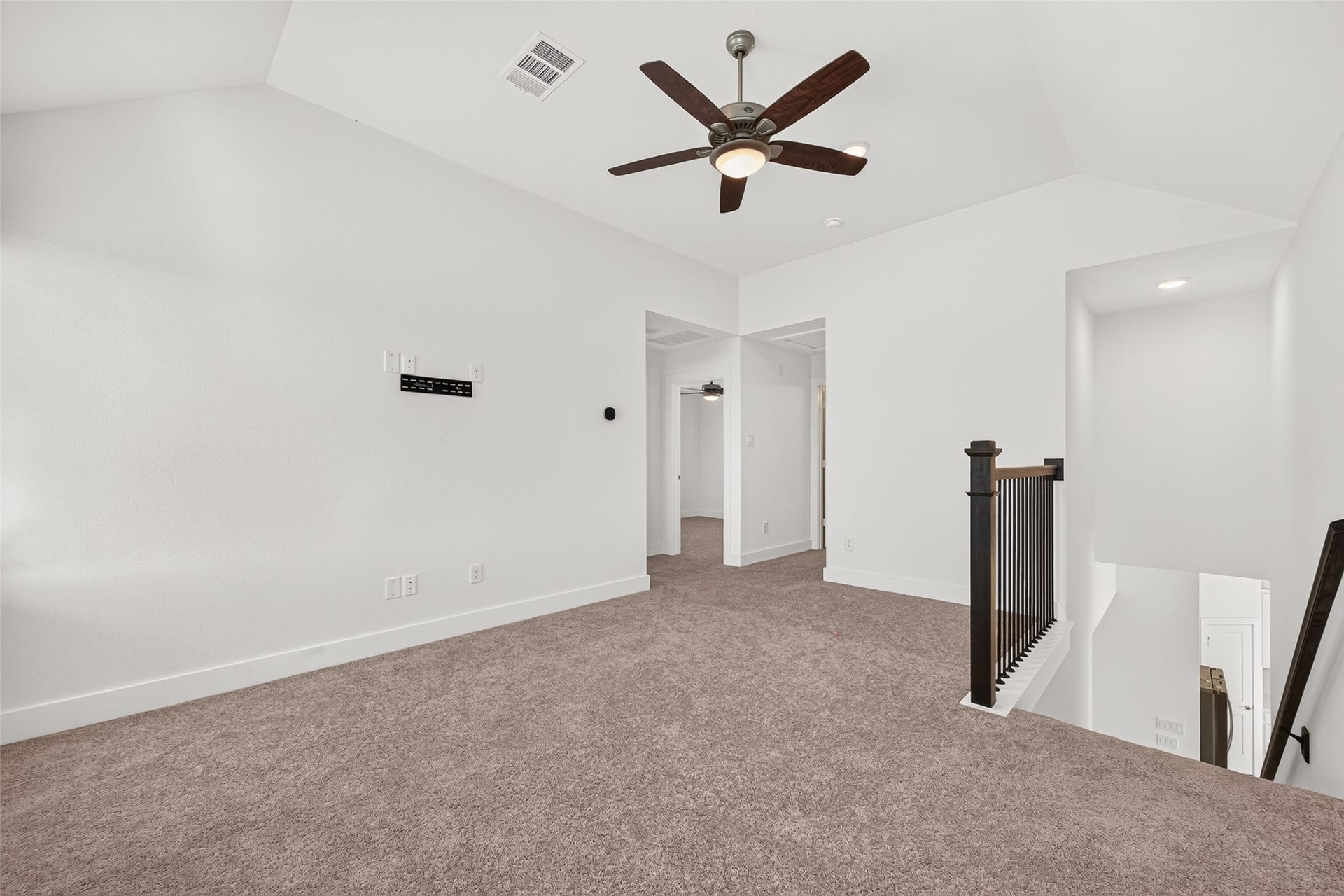 2002 Flatland Drive, Rosenberg, TX 77471 Upstairs loft/game room with carpet, ceiling fan, and stair railing.