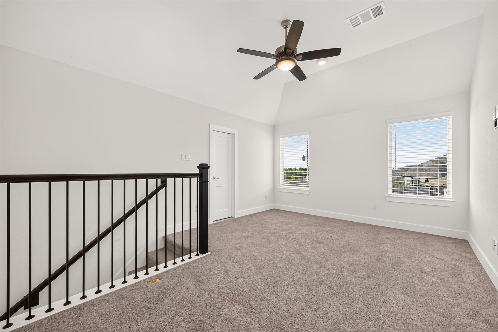 2002 Flatland Drive, Rosenberg, TX 77471 Upstairs loft with iron railing overlooking the staircase and two windows.