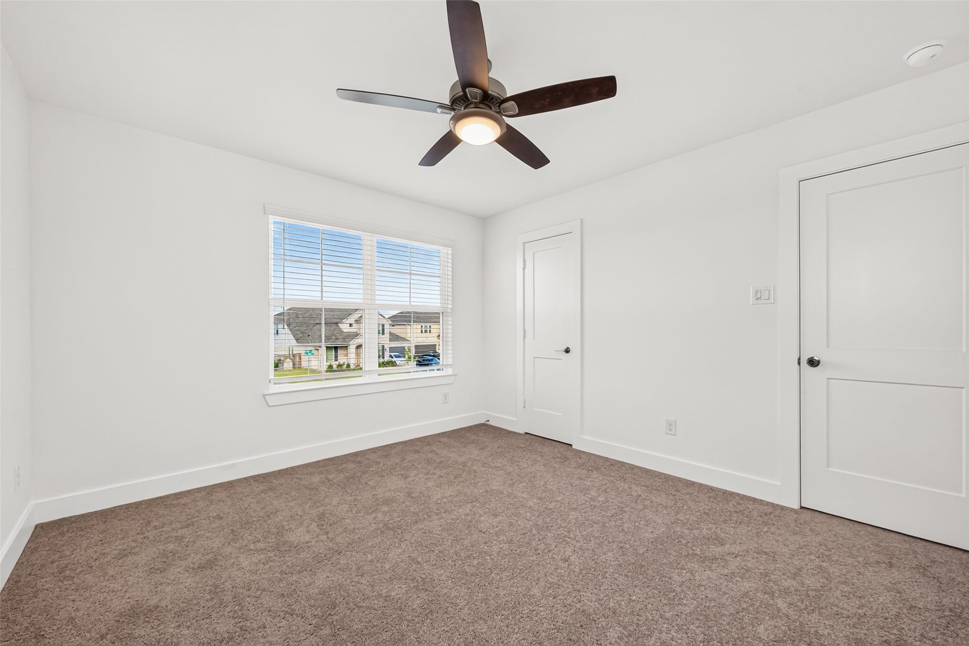 2002 Flatland Drive, Rosenberg, TX 77471 Upstairs bedroom with carpet, ceiling fan, window, and closet.