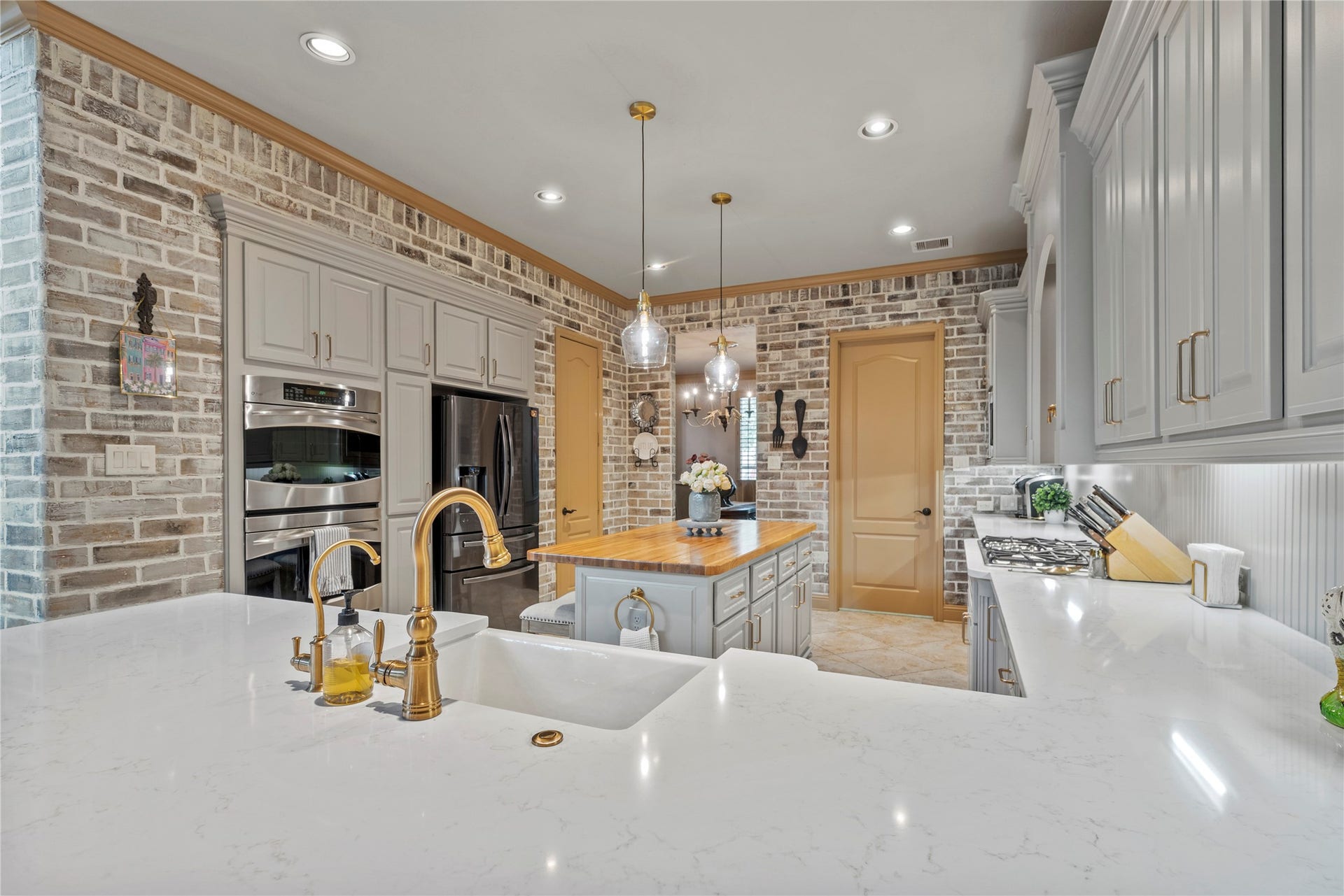 12002 Tall Haven Lane, Cypress, TX 77433 Another angle of the kitchen, showcasing the generous counter space, painted brick walls, and ample storage.