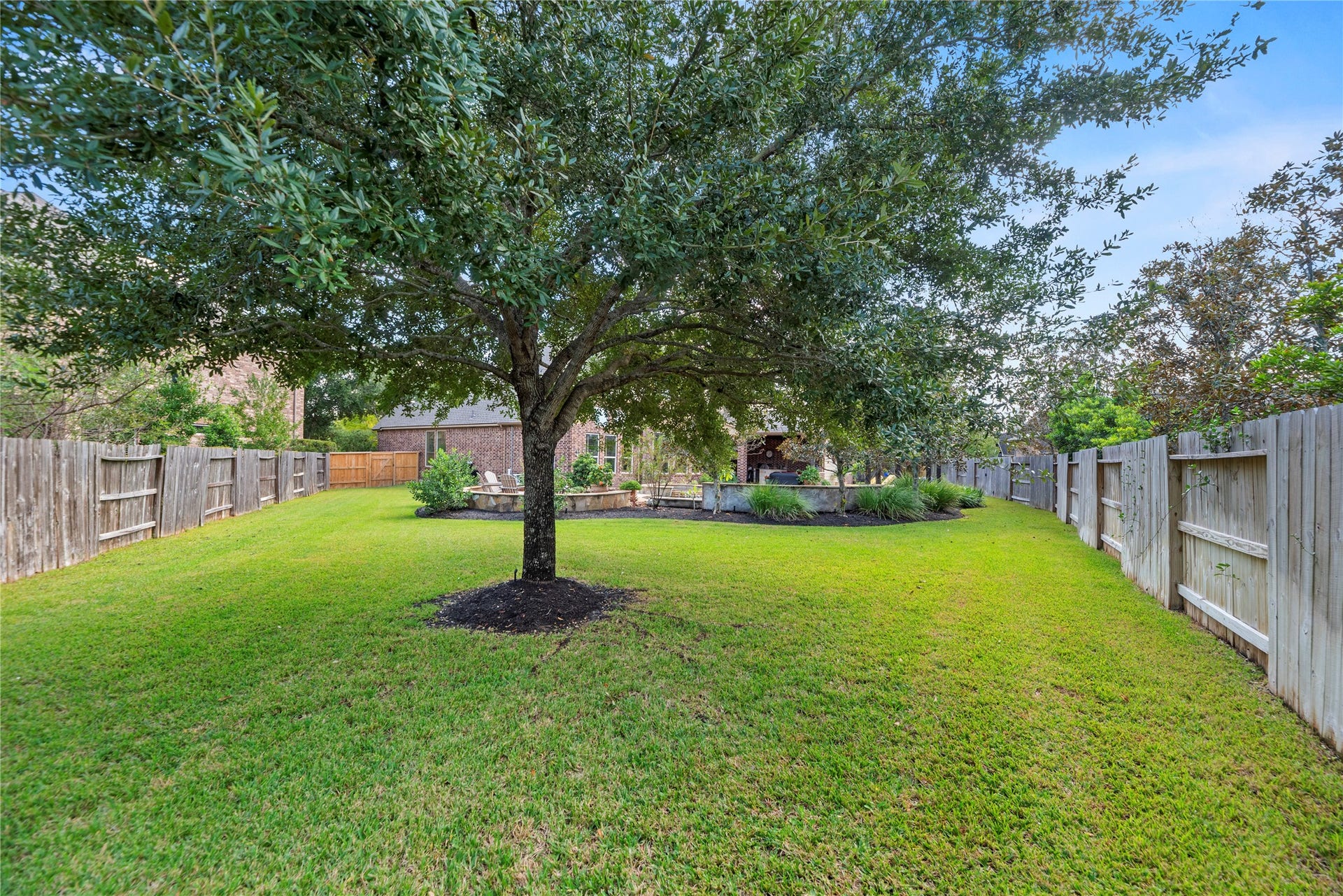 12002 Tall Haven Lane, Cypress, TX 77433 Expansive backyard with lush green grass, mature shade trees, and plenty of open space for outdoor activities.
