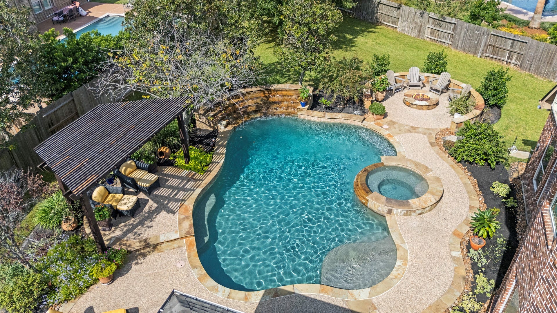 12002 Tall Haven Lane, Cypress, TX 77433 Stunning aerial view of the backyard oasis, highlighting the sparkling swimming pool, spacious patio, and covered outdoor entertaining area.