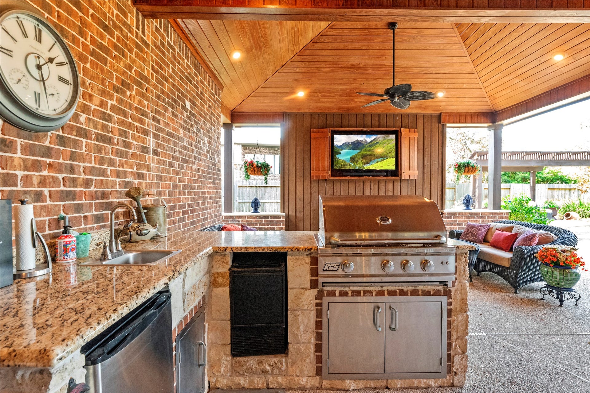 12002 Tall Haven Lane, Cypress, TX 77433 Outdoor kitchen and bar area with brick accents, perfect for hosting gatherings and enjoying time outdoors.