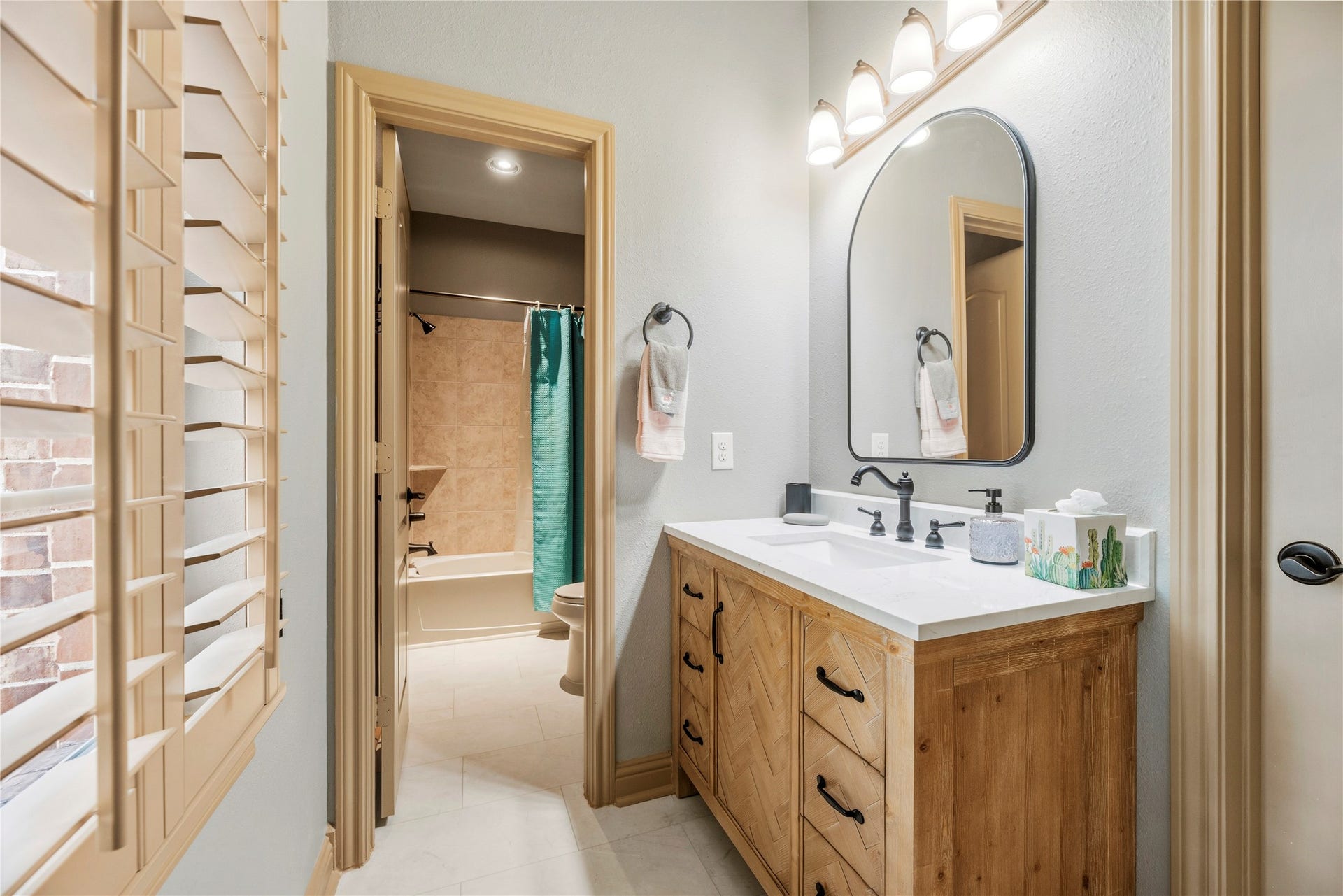 12002 Tall Haven Lane, Cypress, TX 77433 Bathroom with a beautiful vanity, decorative mirror, and warm finishes.