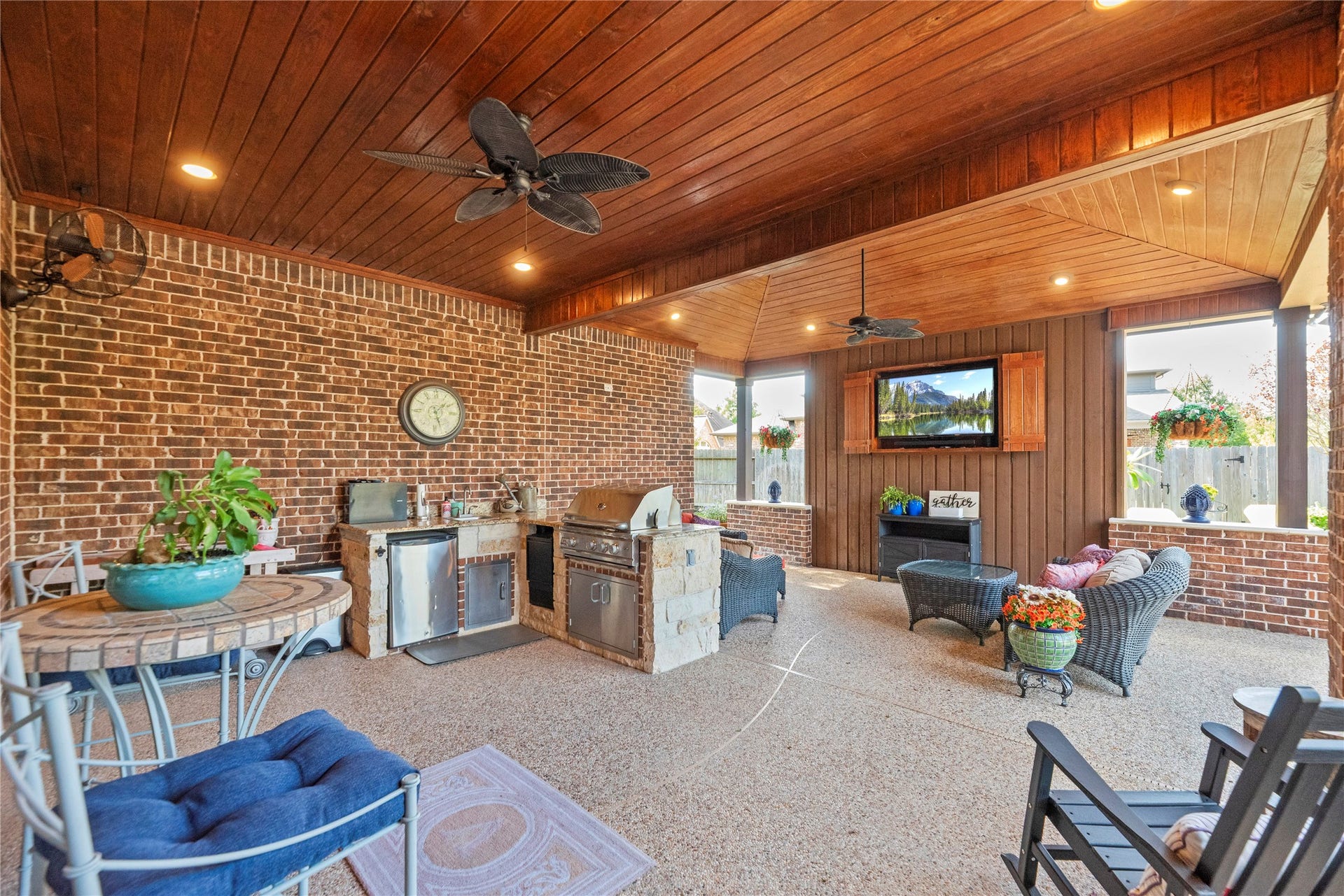 12002 Tall Haven Lane, Cypress, TX 77433 Spacious covered outdoor living area featuring a wood-paneled ceiling, ceiling fans, and plenty of room for entertaining.