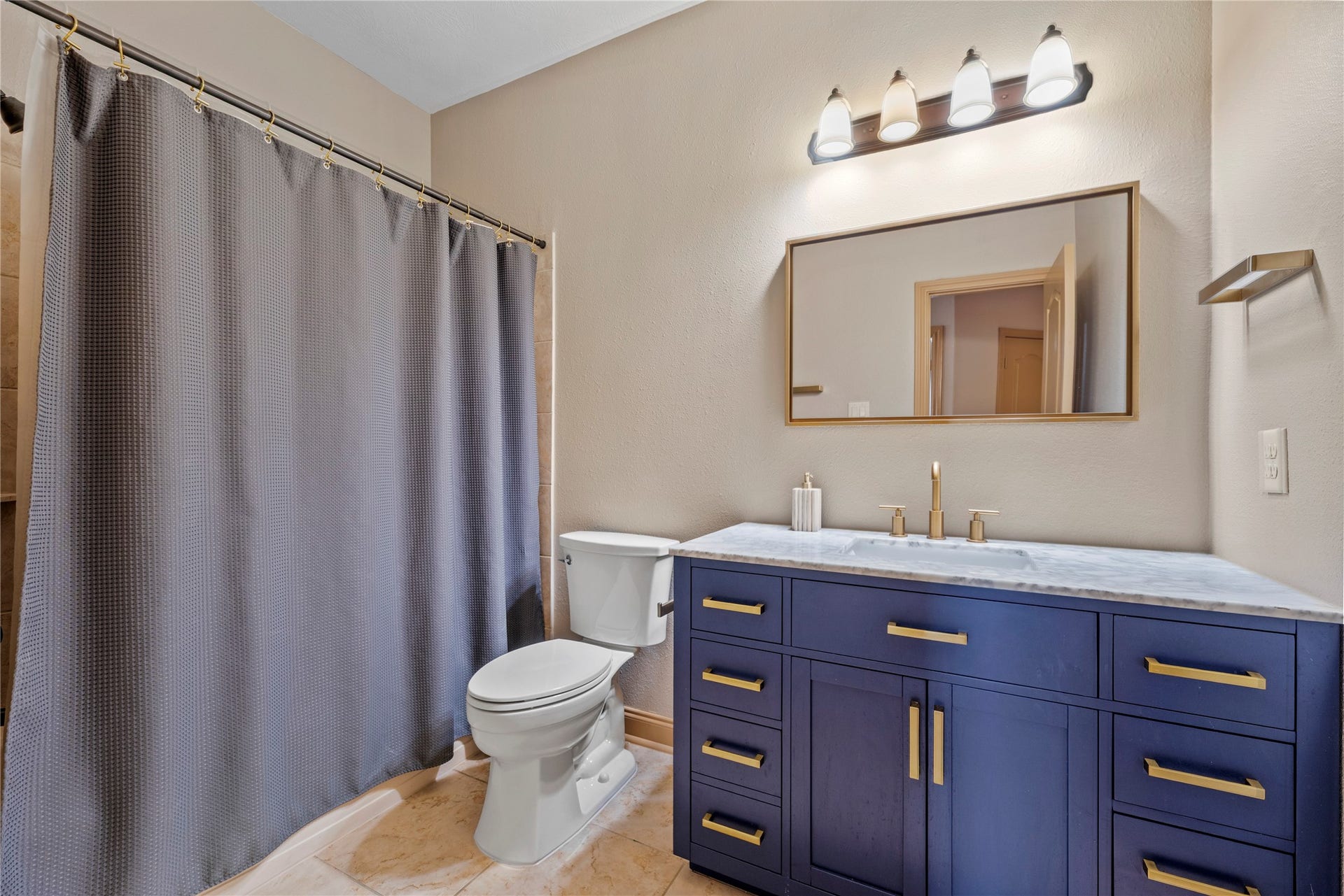 12002 Tall Haven Lane, Cypress, TX 77433 Bathroom number 4, featuring a stylish blue vanity, and shower and tub combination.
