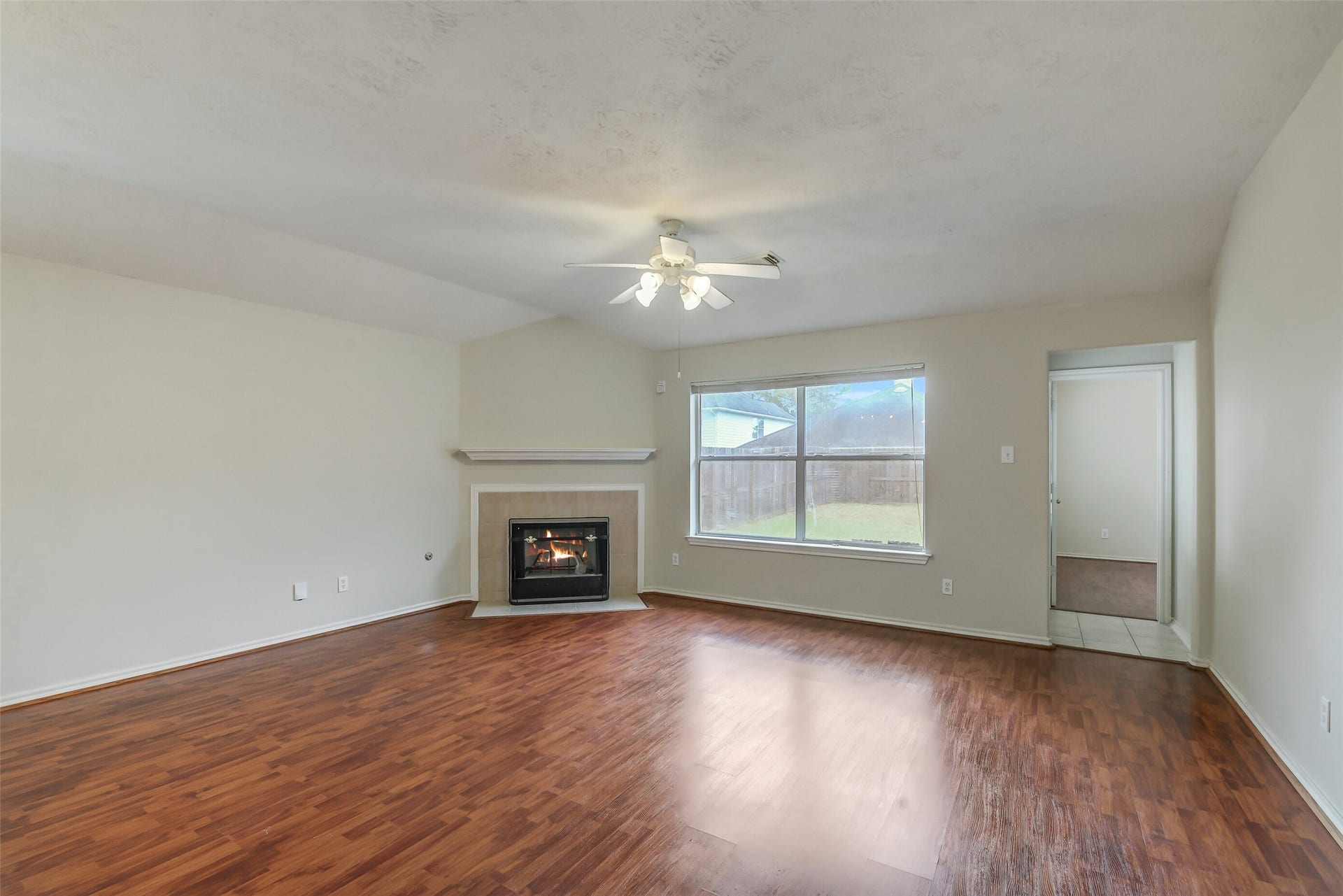 12115 Lucky Meadow Dr, Tomball, TX 77375 Spacious living and dining combination featuring a cozy fireplace, perfect for relaxing and enjoying warm gatherings during the winter months.