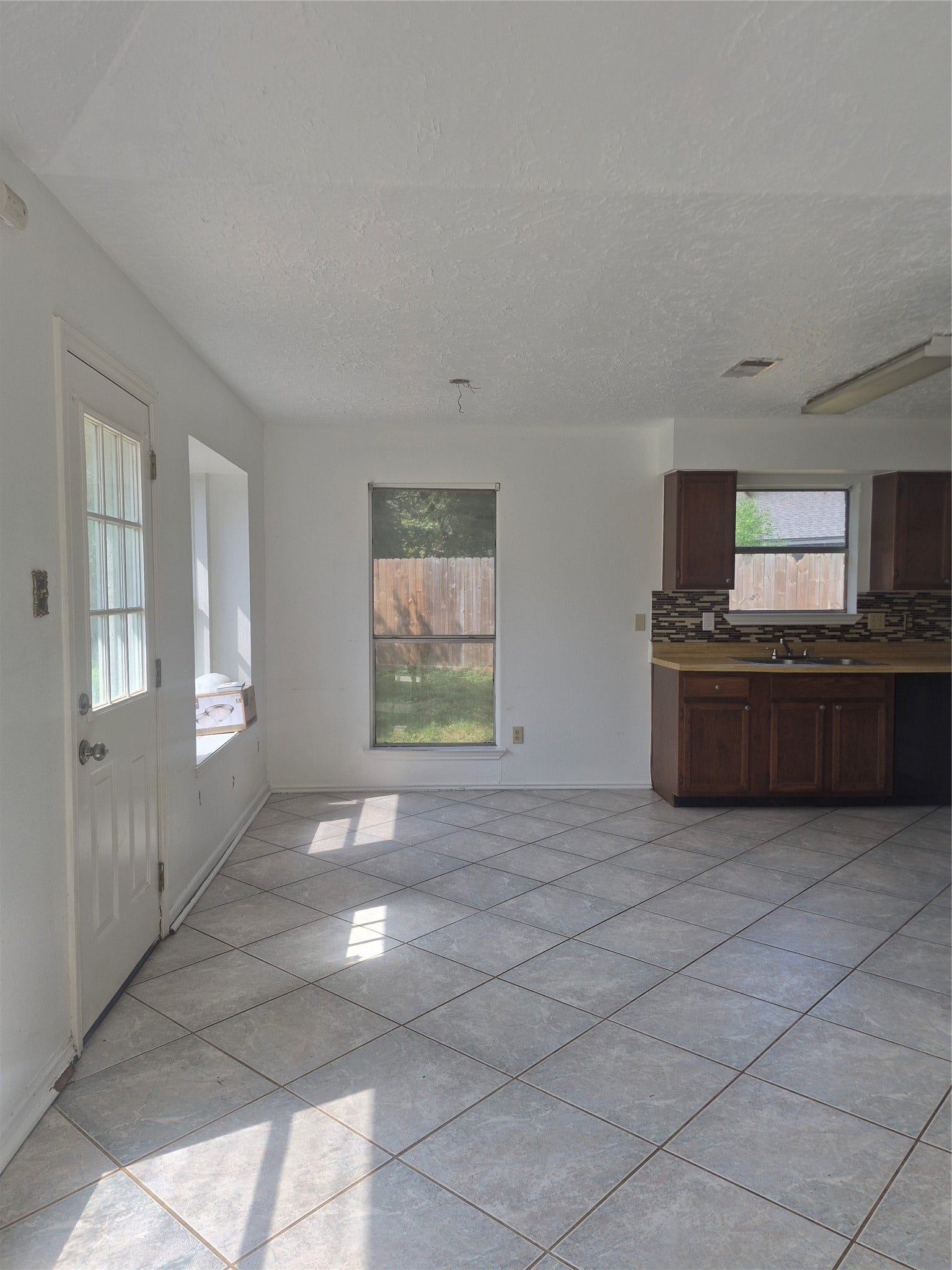 10603 Village Trail Drive, Houston, TX 77065 Kitchen with large windows, tile flooring, offering a view of the backyard.