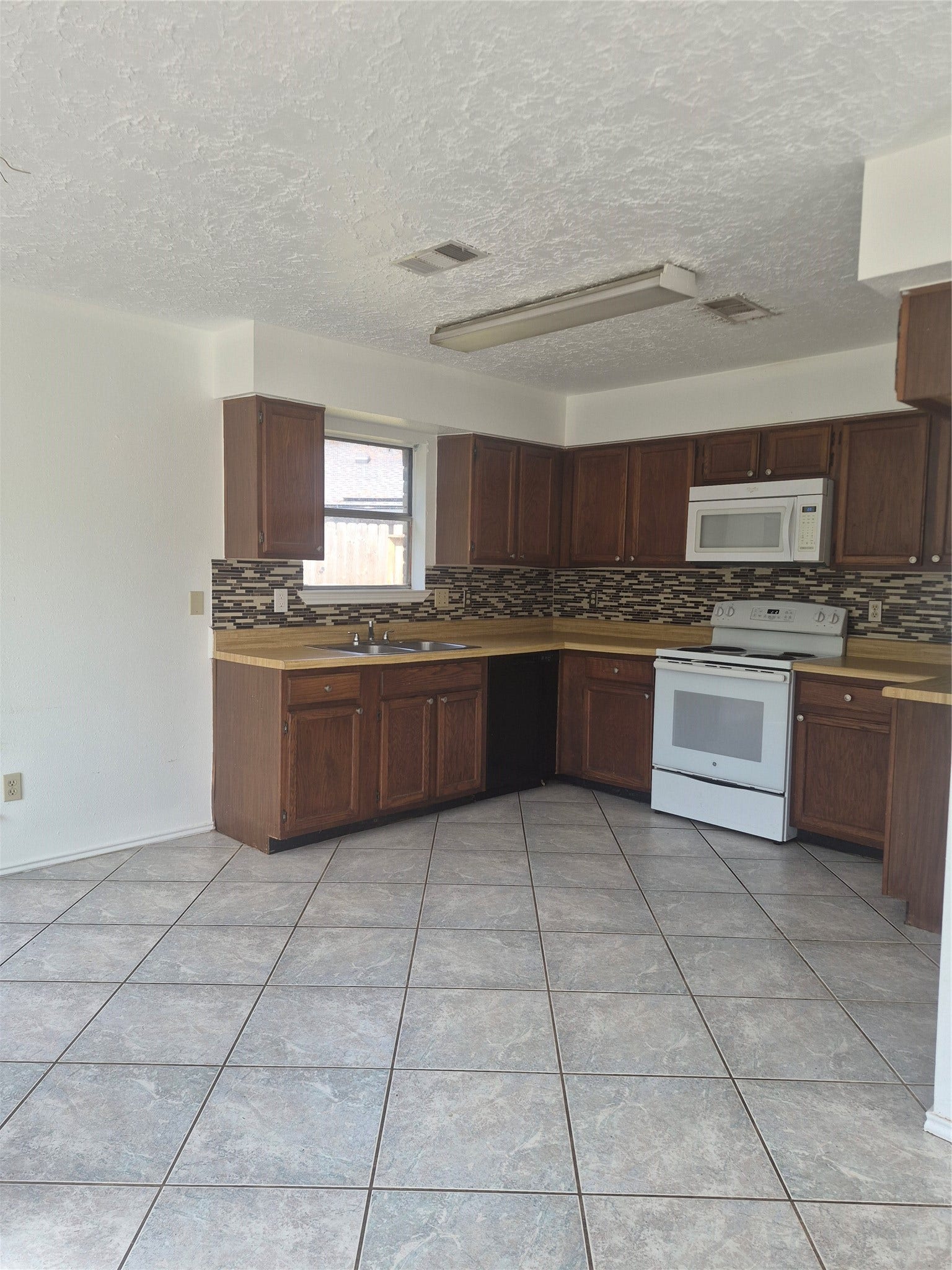 10603 Village Trail Drive, Houston, TX 77065 Dark wood cabinets, modern tile backsplash, and ample counter space.