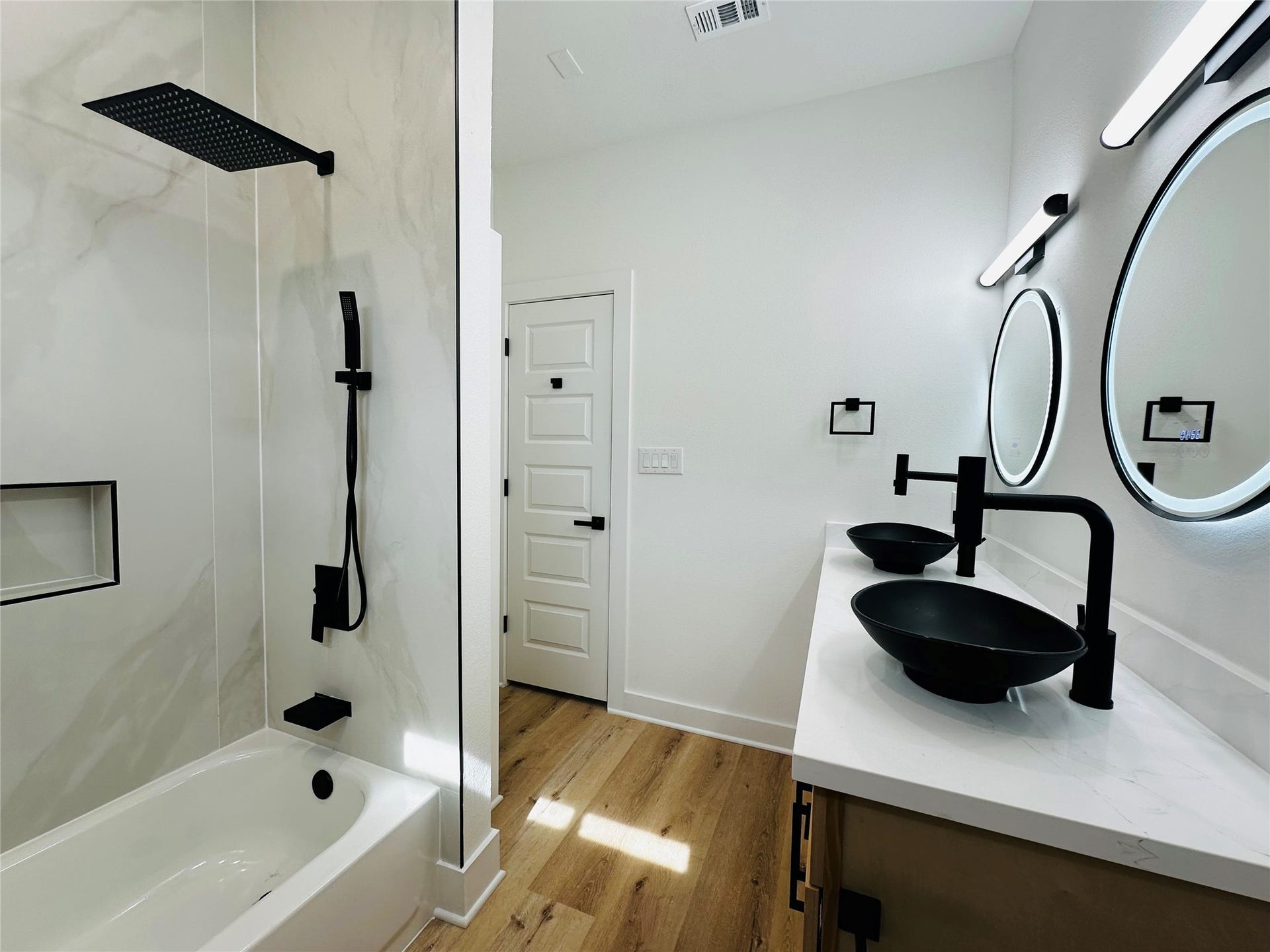 Unit C Bath. bathroom feature 4ft x 9ft porcelain tile wall slabs, push button toilets, matte black hardware, matte black pull out multi function vanity faucets, multi color led mirros, double stacked head knocker cabinets, illuminated soap niches, upgraded shower faucets with handheld sprayer, and more.