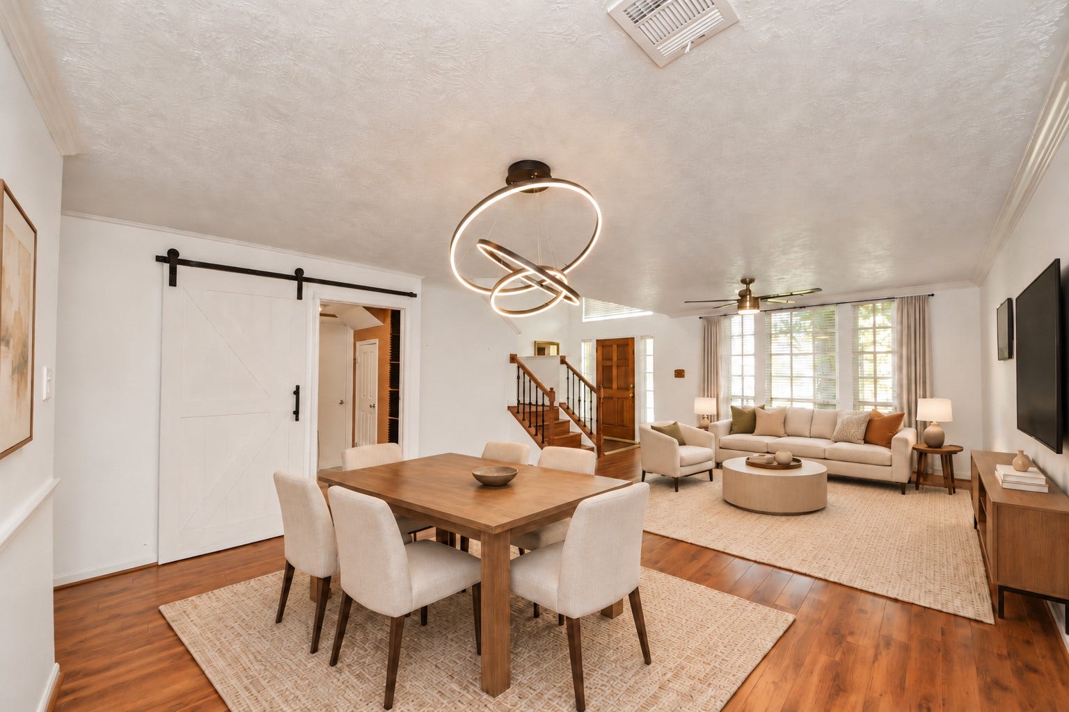 15007 Moss Boulder Court, Houston, TX 77084 Virtually staged dining area featuring a contemporary light fixture and adjoining living space.