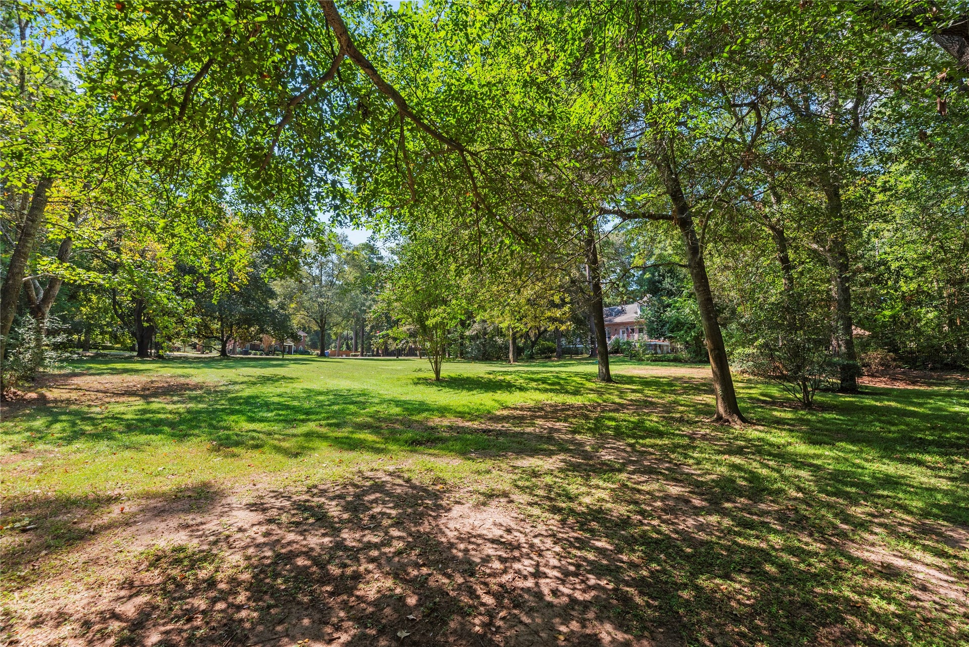 Another view of the spacious lot, with mature landscaping and seasonal blooms