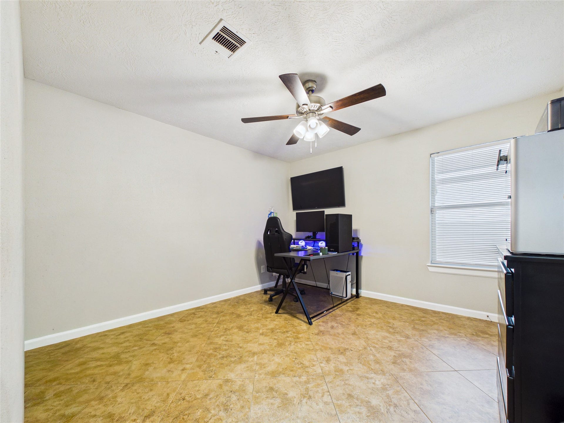 9022 Barracuda Drive, Texas City, TX 77591 Spacious 2nd bedroom with neutral walls, tile flooring, and a ceiling fan.