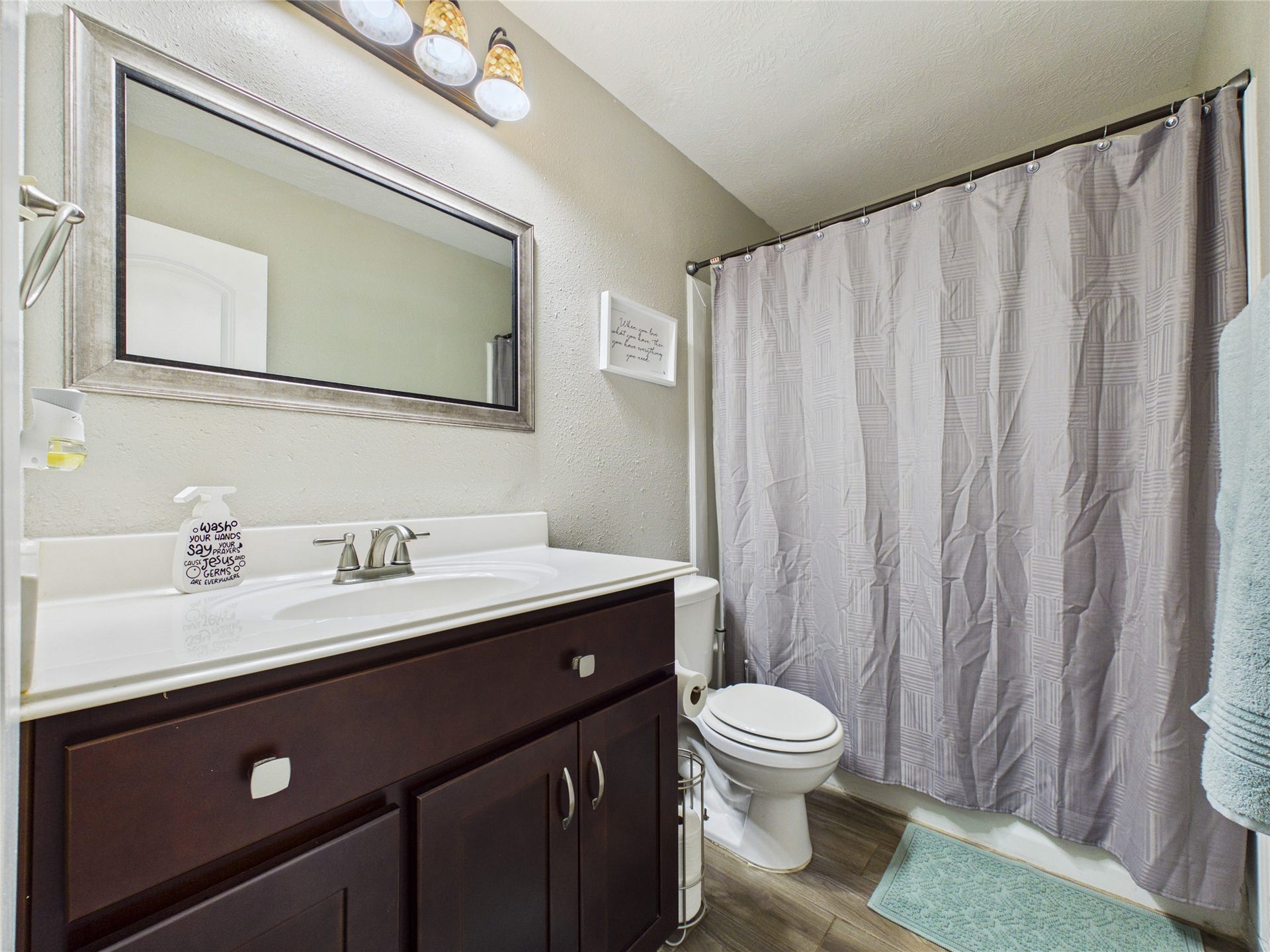 9022 Barracuda Drive, Texas City, TX 77591 This secondary bathroom features dark wood cabinetry, a modern countertop, bath/shower combo.