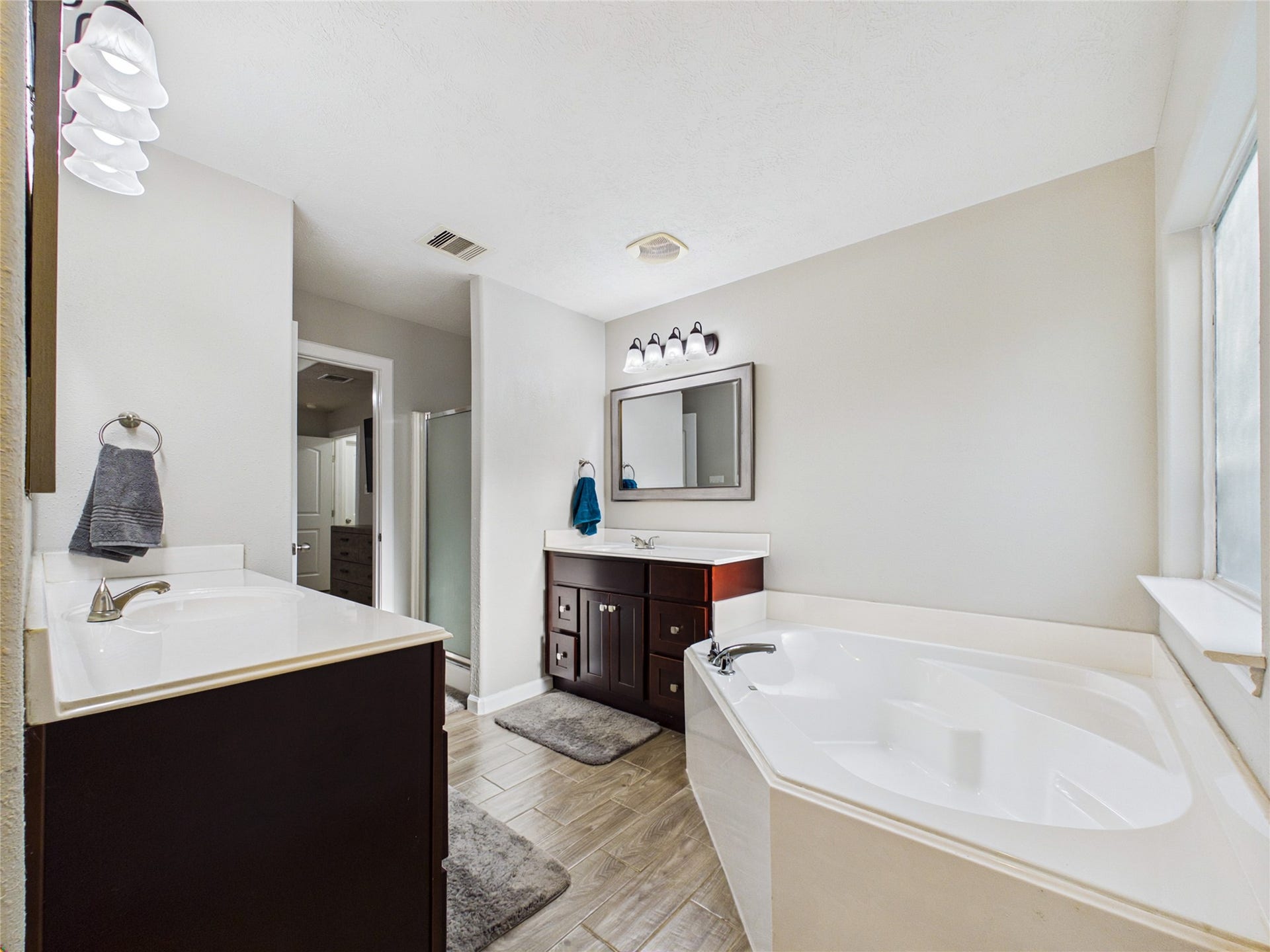 9022 Barracuda Drive, Texas City, TX 77591 Primary bathroom featuring his-and-hers vanities, a spacious soaking tub, and a separate shower.