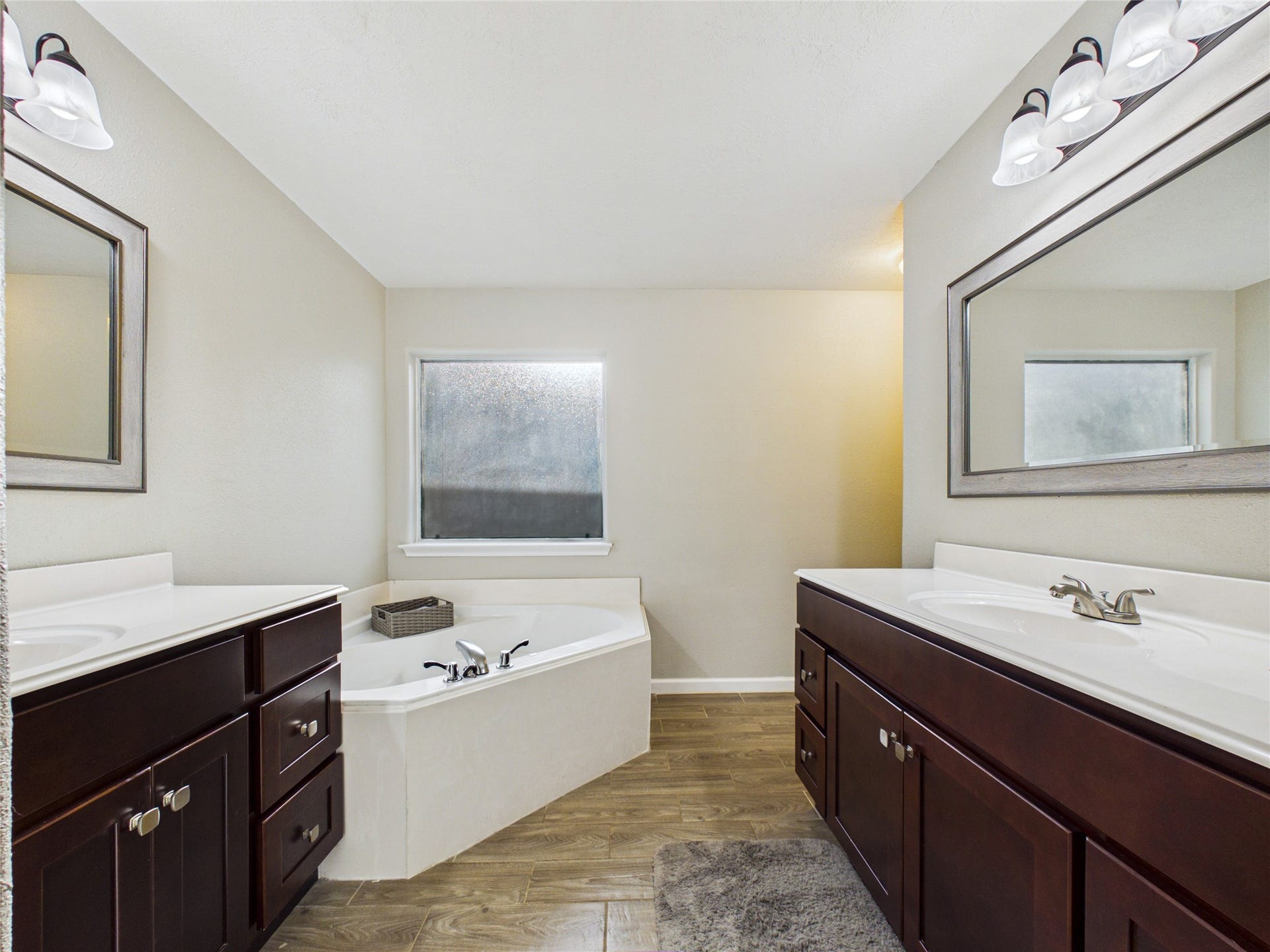 9022 Barracuda Drive, Texas City, TX 77591 Primary bathroom featuring his-and-hers vanities, a spacious soaking tub, and a separate shower.