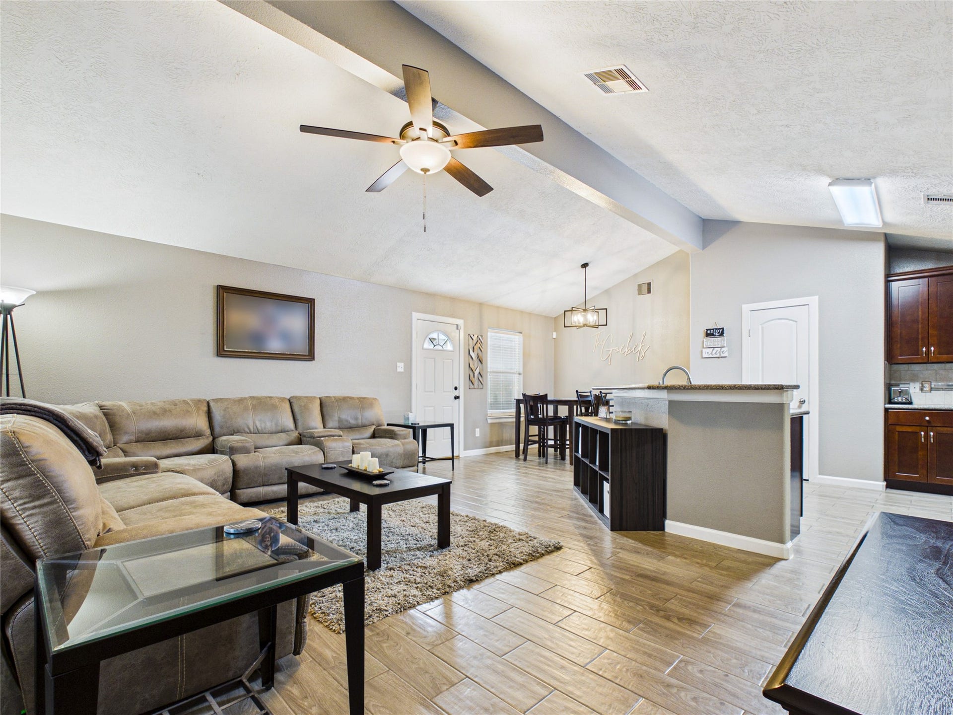 9022 Barracuda Drive, Texas City, TX 77591 Spacious open-concept living area with vaulted ceilings, seamlessly connected to a modern kitchen with a breakfast bar and dining area.